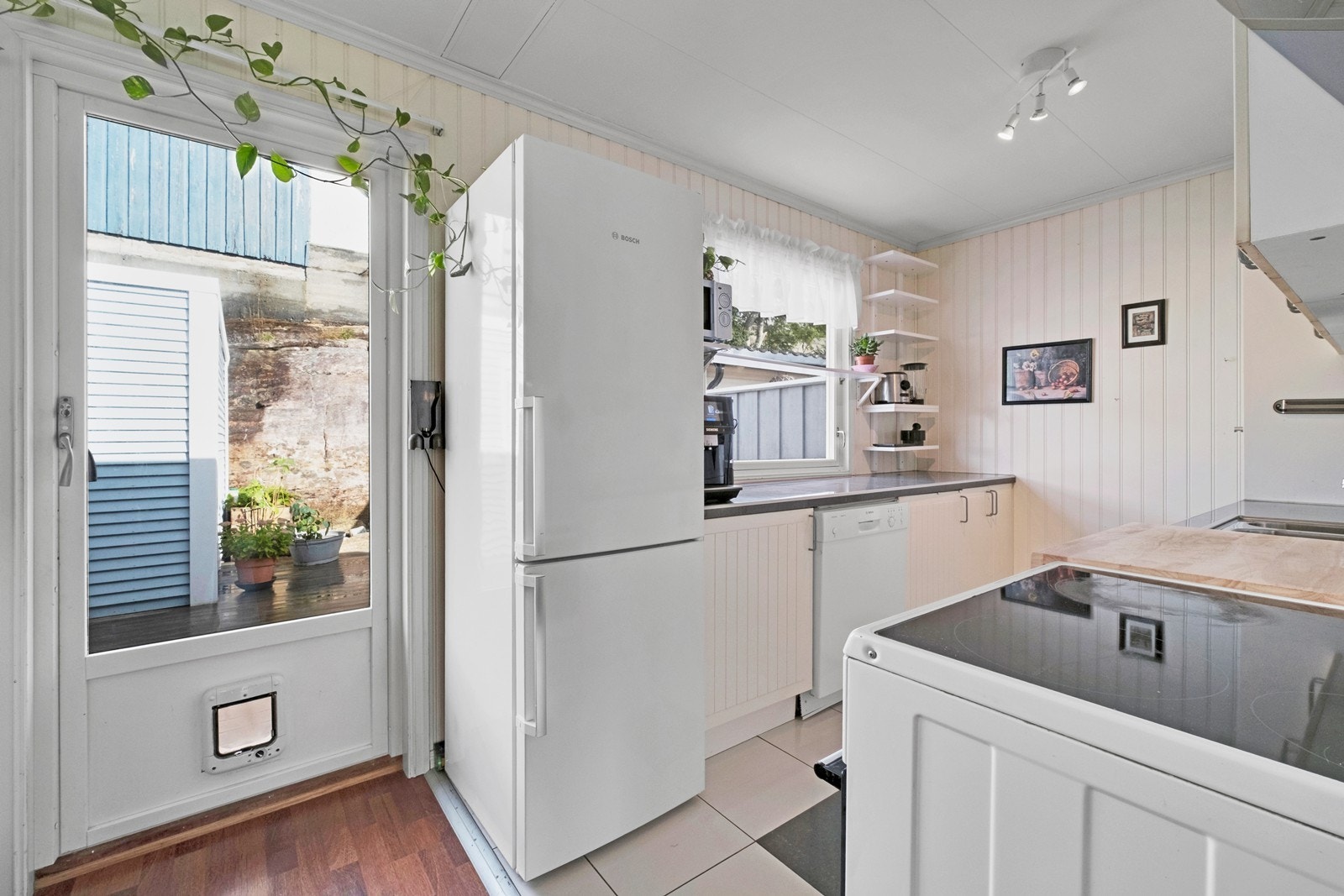 Mellom spisestuen og kjøkkenet har man utgang til markterrasse. Galleribilde