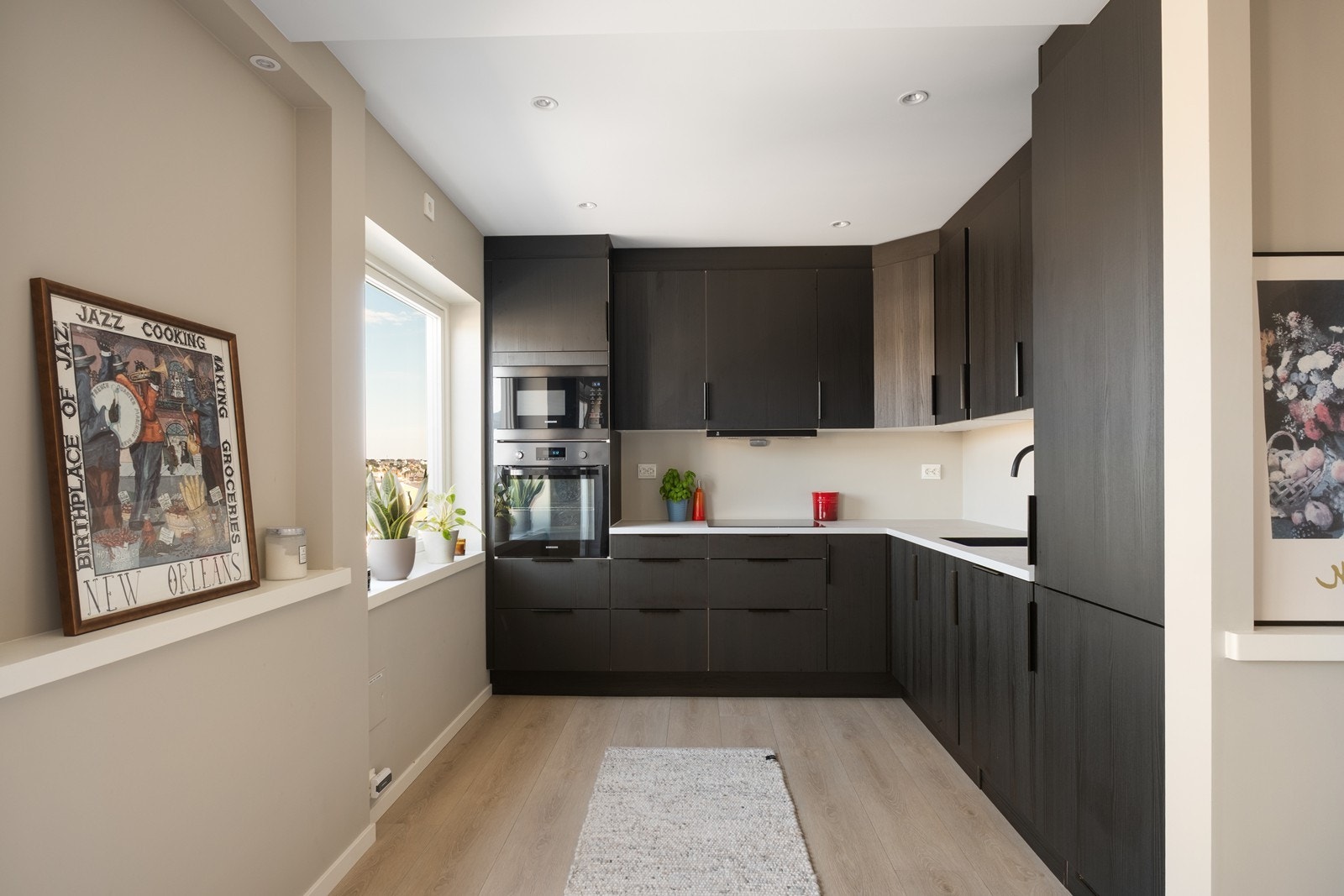 Kjøkkenet har en moderne kjøkkeninnredning med mørke fronter og integrerte hvitevarer. Galleribilde