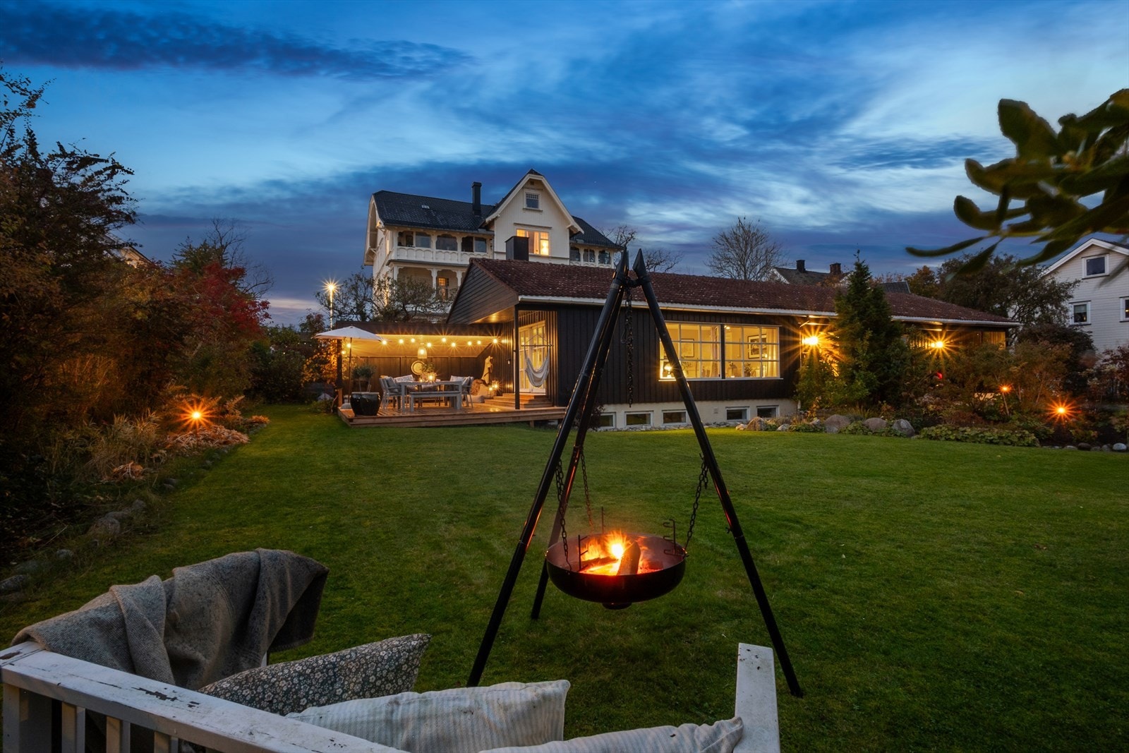 Den romslige hagen byr på grønne uteområder og en lun atmosfære, perfekt for avslapning eller hyggelige kvelder rundt bålpannen. Galleribilde