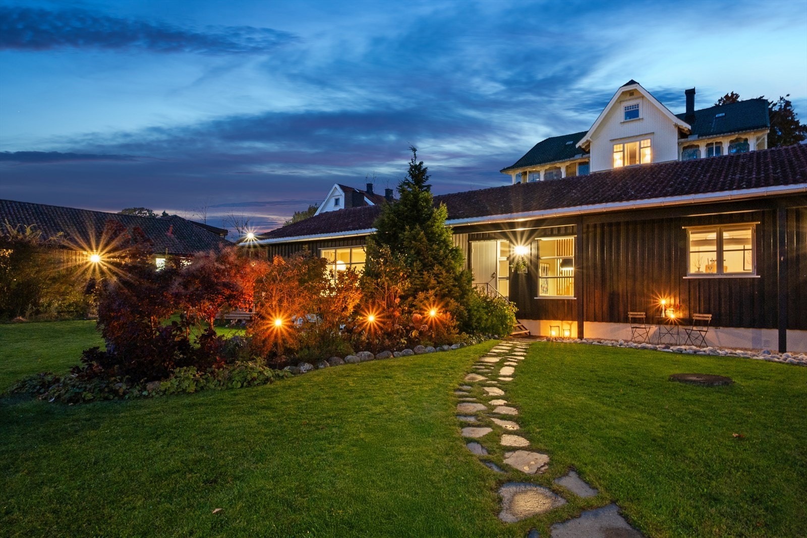 Fra du parkerer bilen i carporten eller i oppkjørselen, ledes du til inngangspartiet via grus- og steinlagte stier i grønne og hyggelige omgivelser. Galleribilde