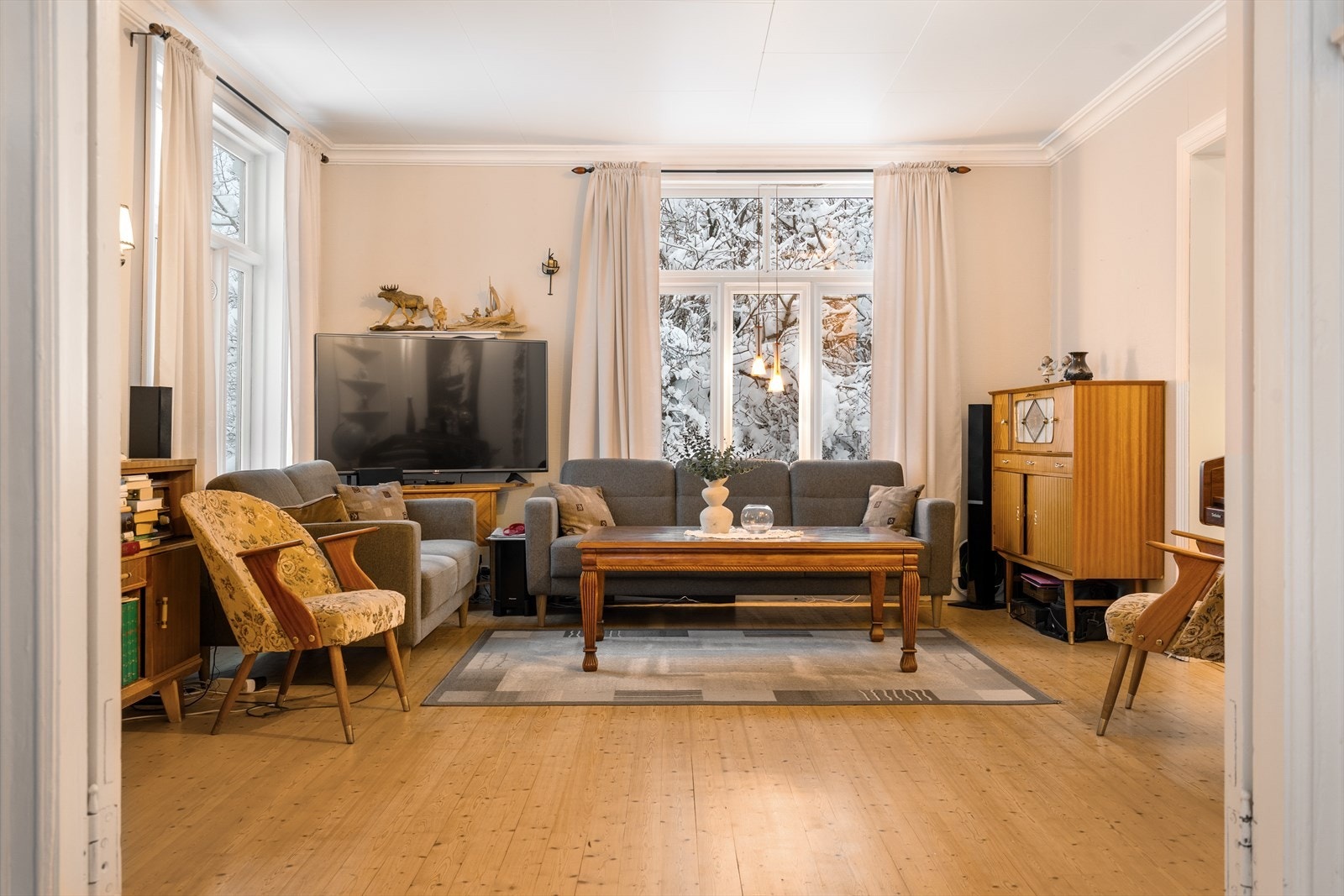 Store vindusflater trekker inn lys og natur og gjør stuen levende gjennom hele dagen. Galleribilde