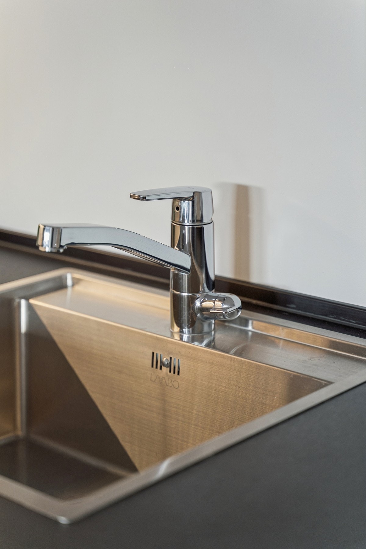 Benkeplaten er av sort laminat og har nedfelt oppvaskkum i rustfritt stål. Galleribilde