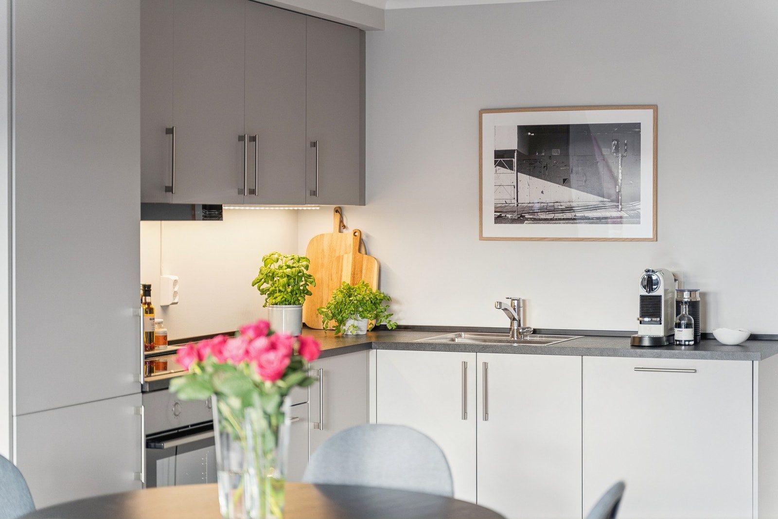 Kjøkkeninnredningen er bygget i en klassisk hjørneløsning, med takoppforede skap på én side Galleribilde