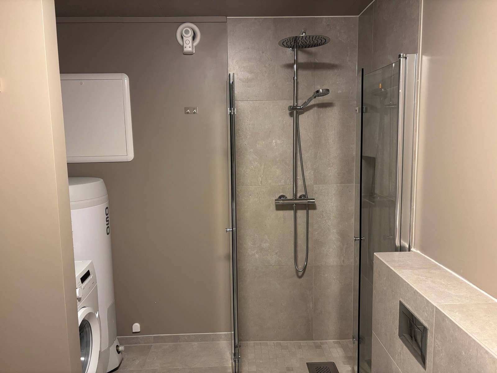 Baderom med opplegg til vaskemaskin og dusjsone. Galleribilde