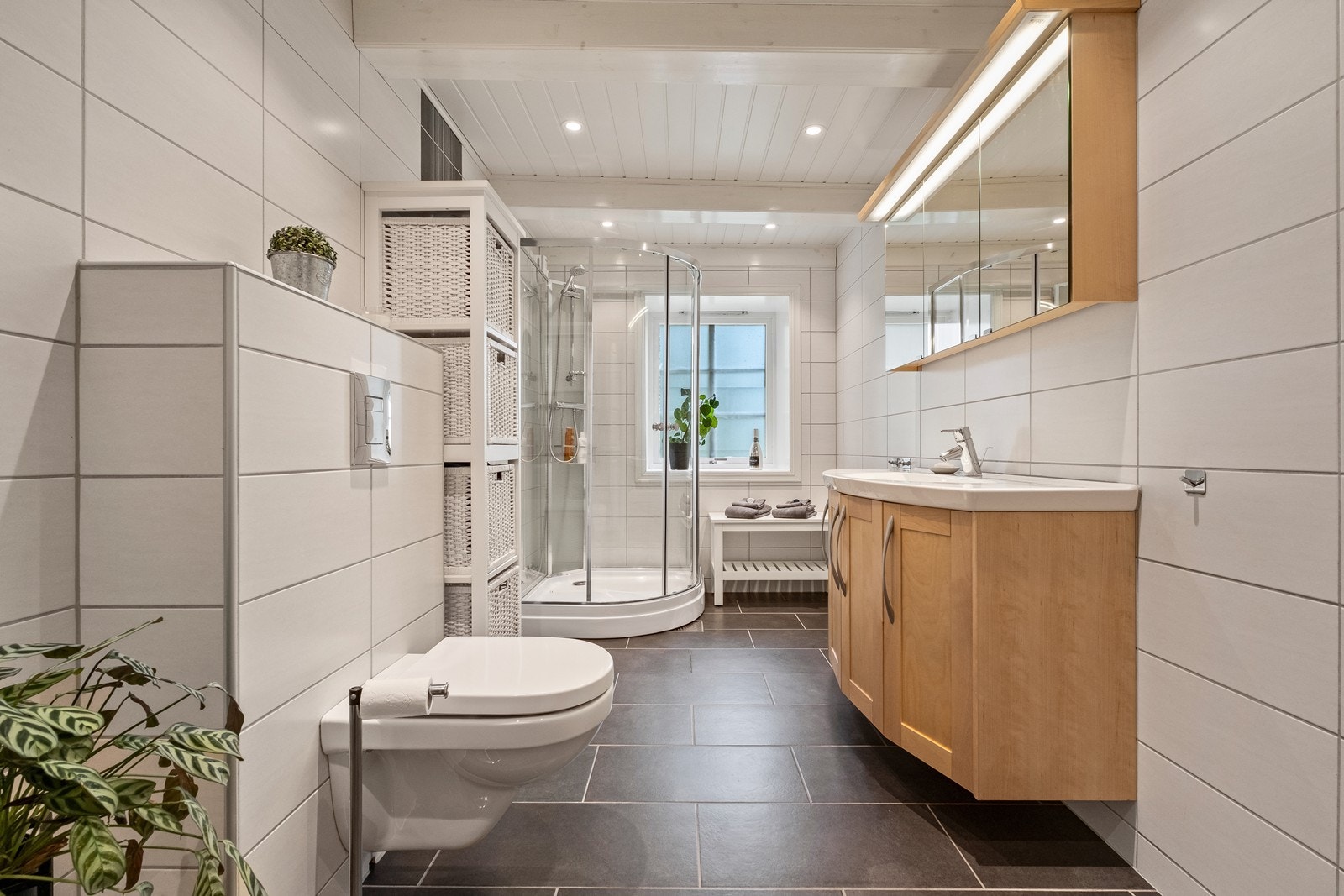 Baderomsinnredning med heldekkende servant, underskap og speilskap med lys. Galleribilde