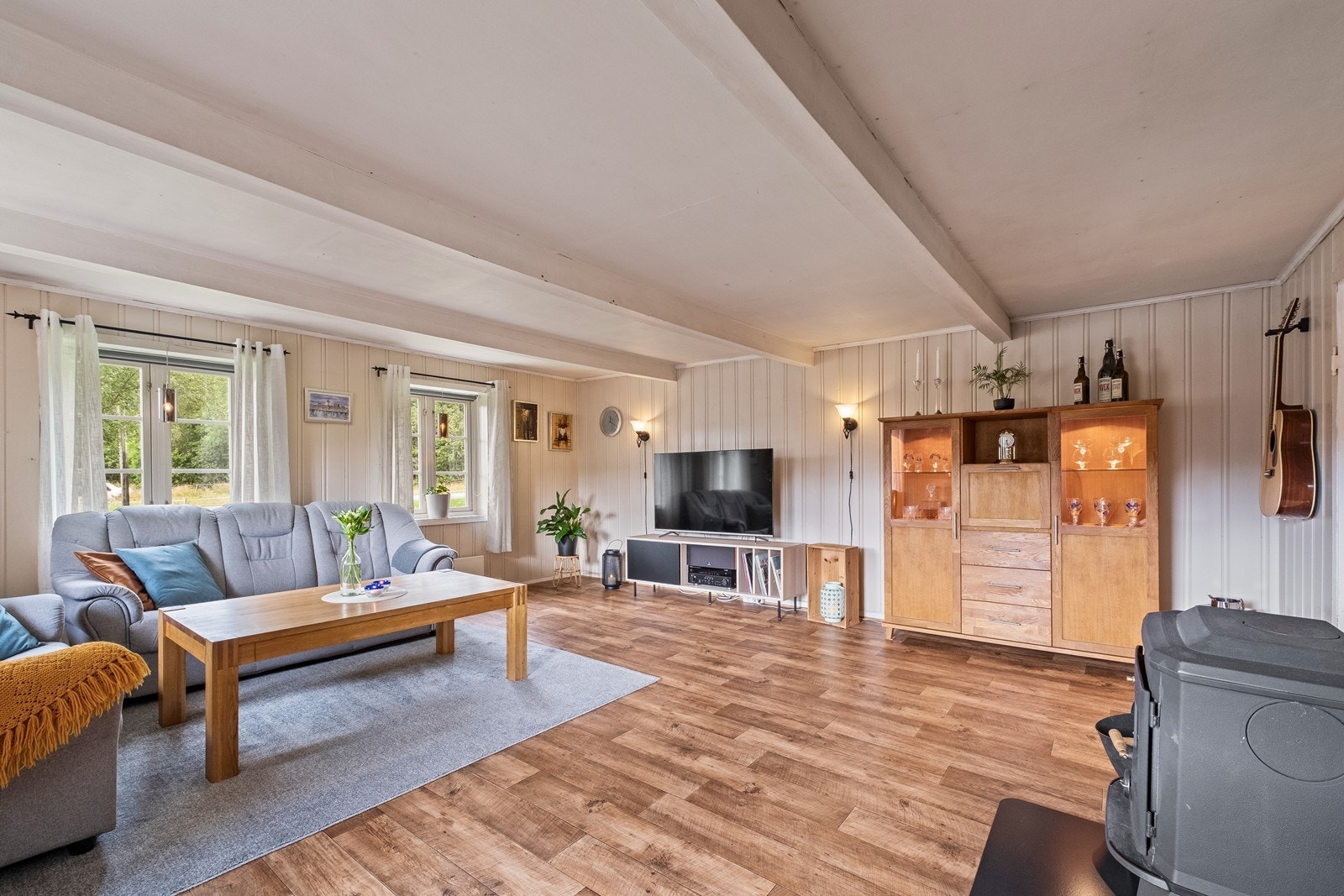 Stuen er romslig og de synlige takbjelkene gir et særegent preg. Galleribilde