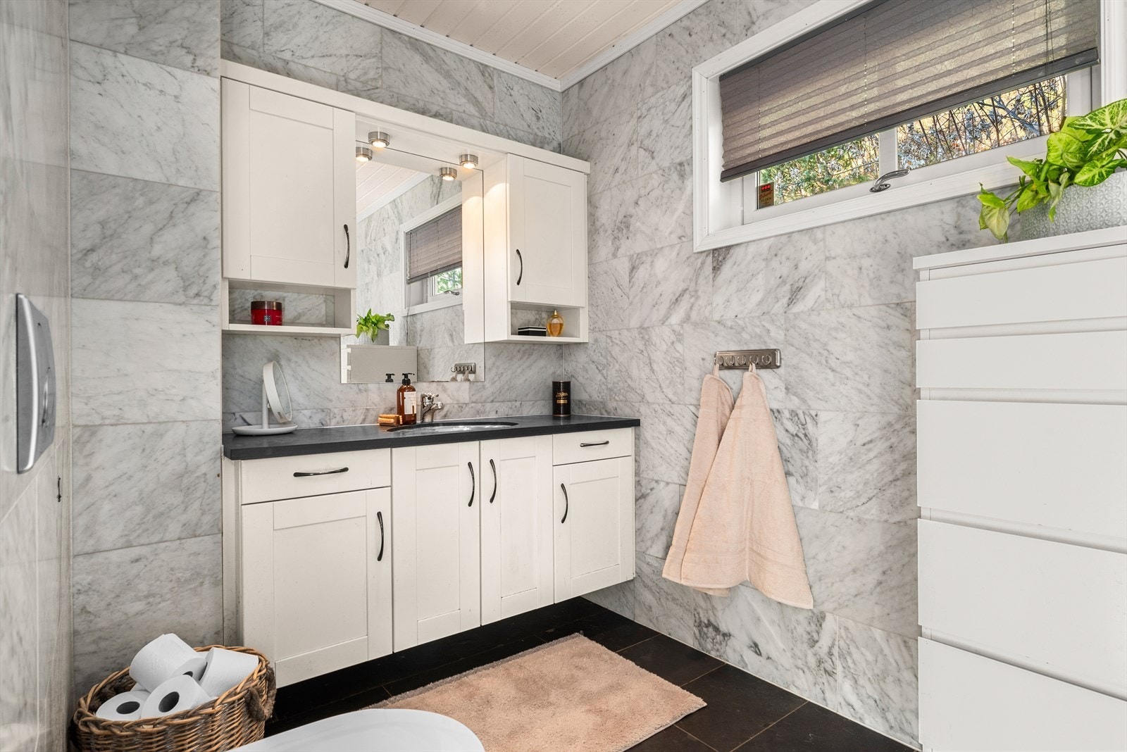 Badet er påkostet med finslipt marmor på vegg og brasiliansk skifer på gulv og benkeplate. Galleribilde