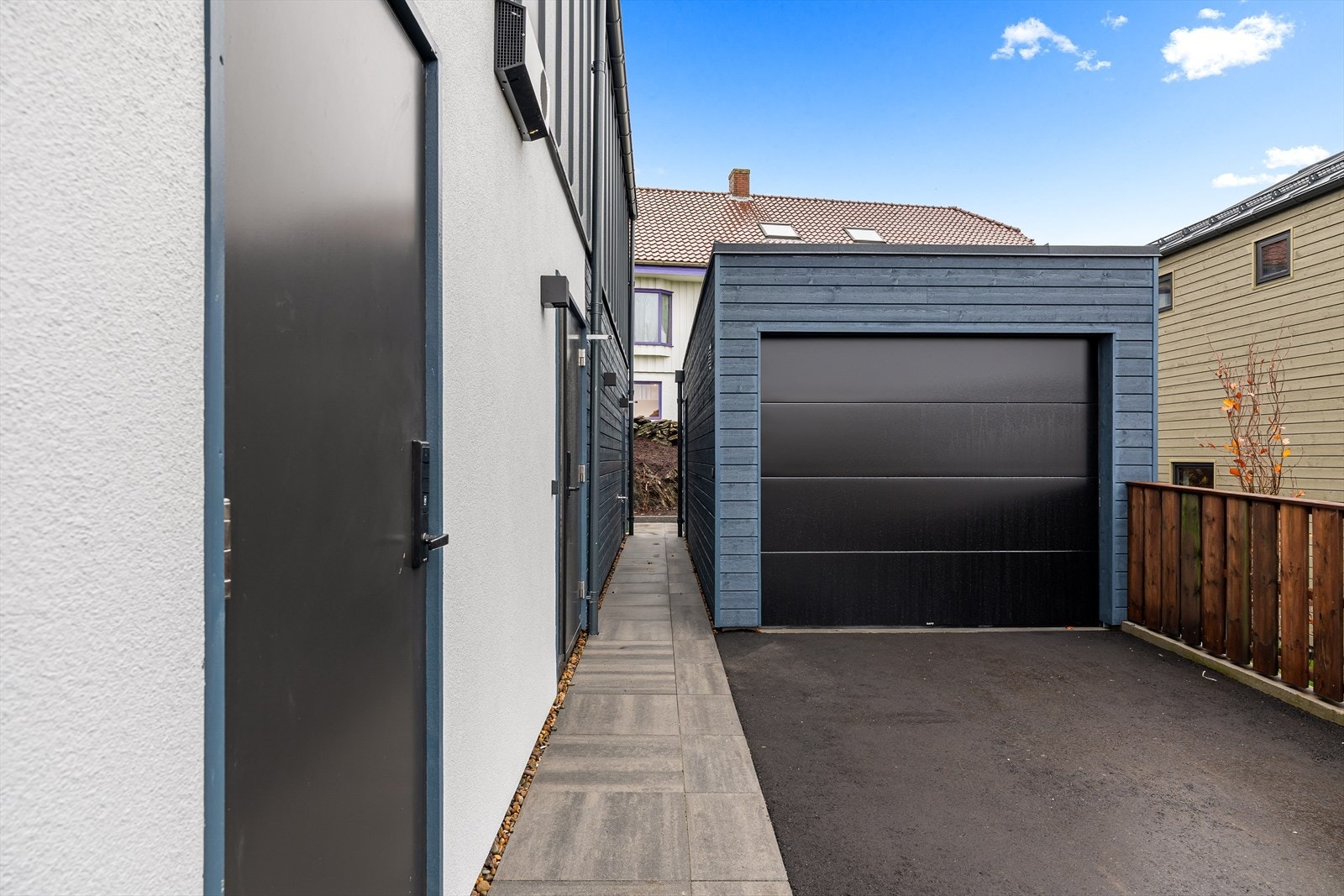 Garasje med automatisk port samt parkeringsplass i gårdsrom. Galleribilde
