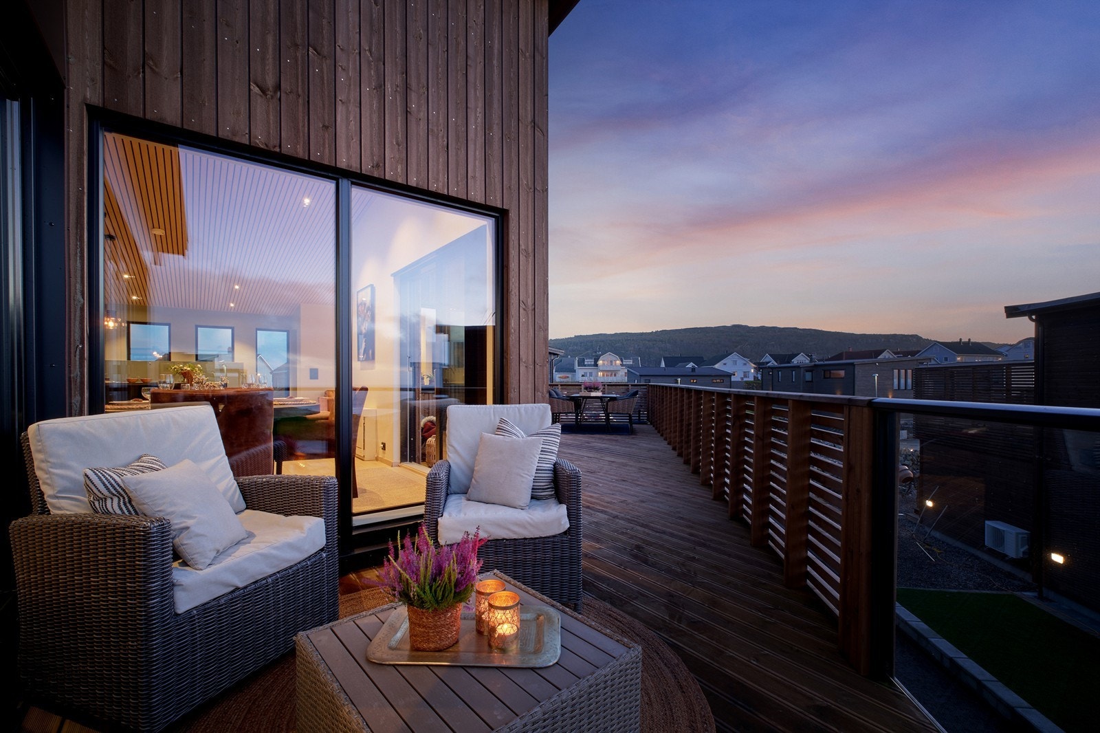 Store vindusflater gir utsyn mot nærliggende boligområde fra terrassen. Galleribilde