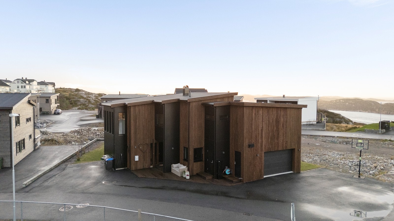 Garasje med elbillader gir praktisk parkering på egen tomt, med asfaltert innkjøring og tun. Galleribilde