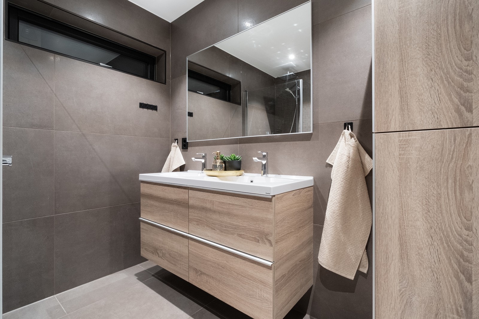 Servanten har to vasker, og i tillegg til underskap er det montert høyskap på veggen. Galleribilde