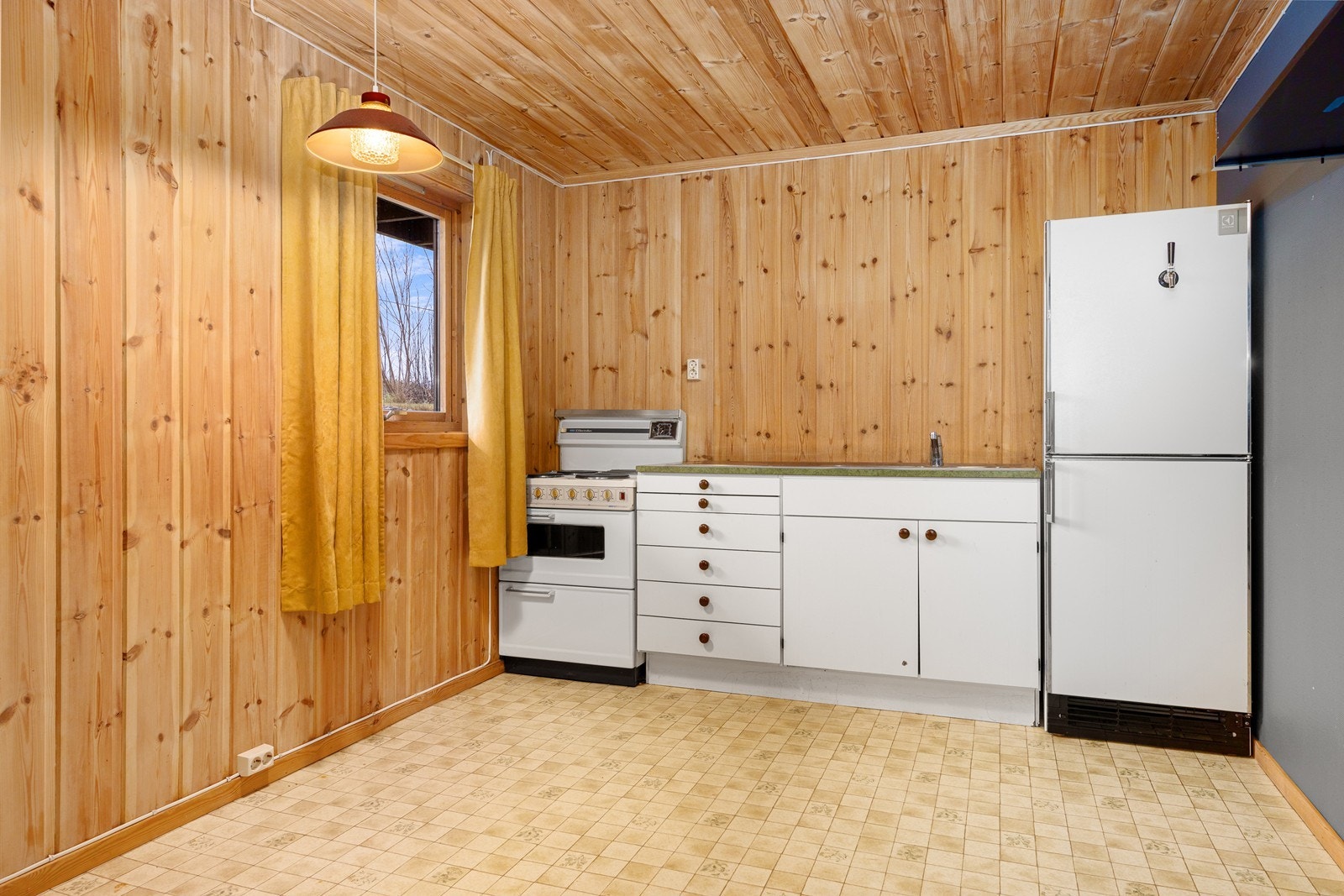 Hybelkjøkkenet har innredning med glatte fronter og benkeplate i laminat, samt vaskekar i rustfritt stål og komfyr. Galleribilde