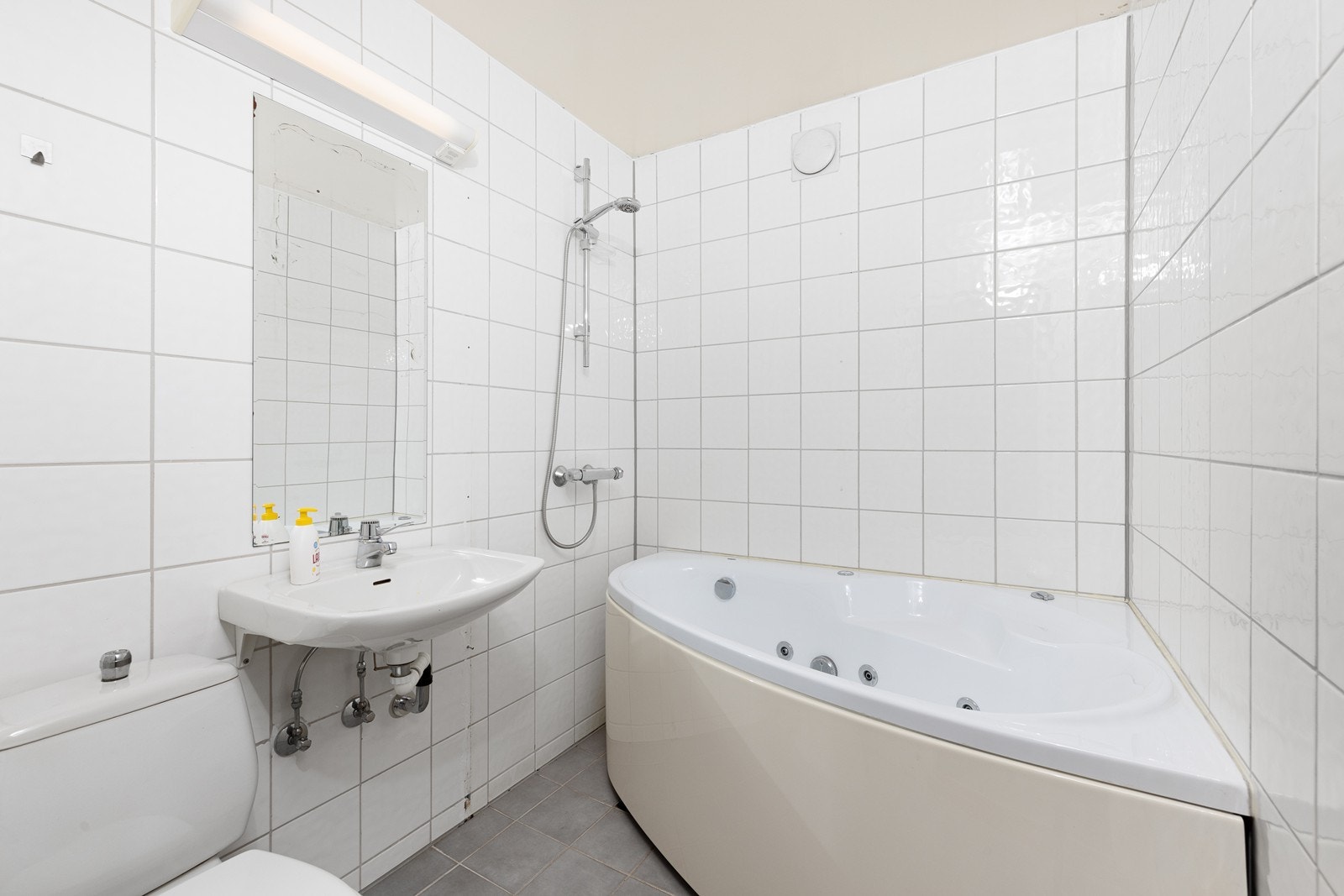 Flislagt bad med elektriske varmekabler og malte plater i tak, utstyrt med toalett, vegghengt servant, badekar og dusj. Rommet er ikke godkjent som rom for varig opphold. Galleribilde