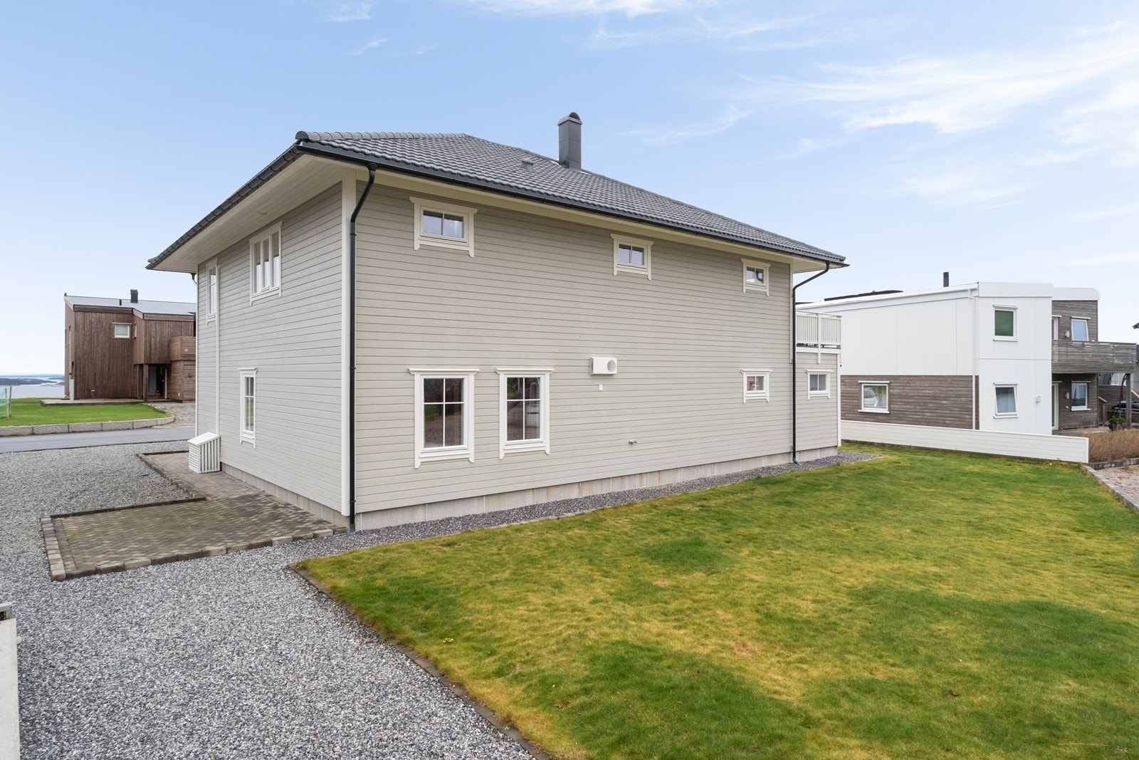 Tomten er opparbeidet med plen, belegningsstein og grus. Galleribilde