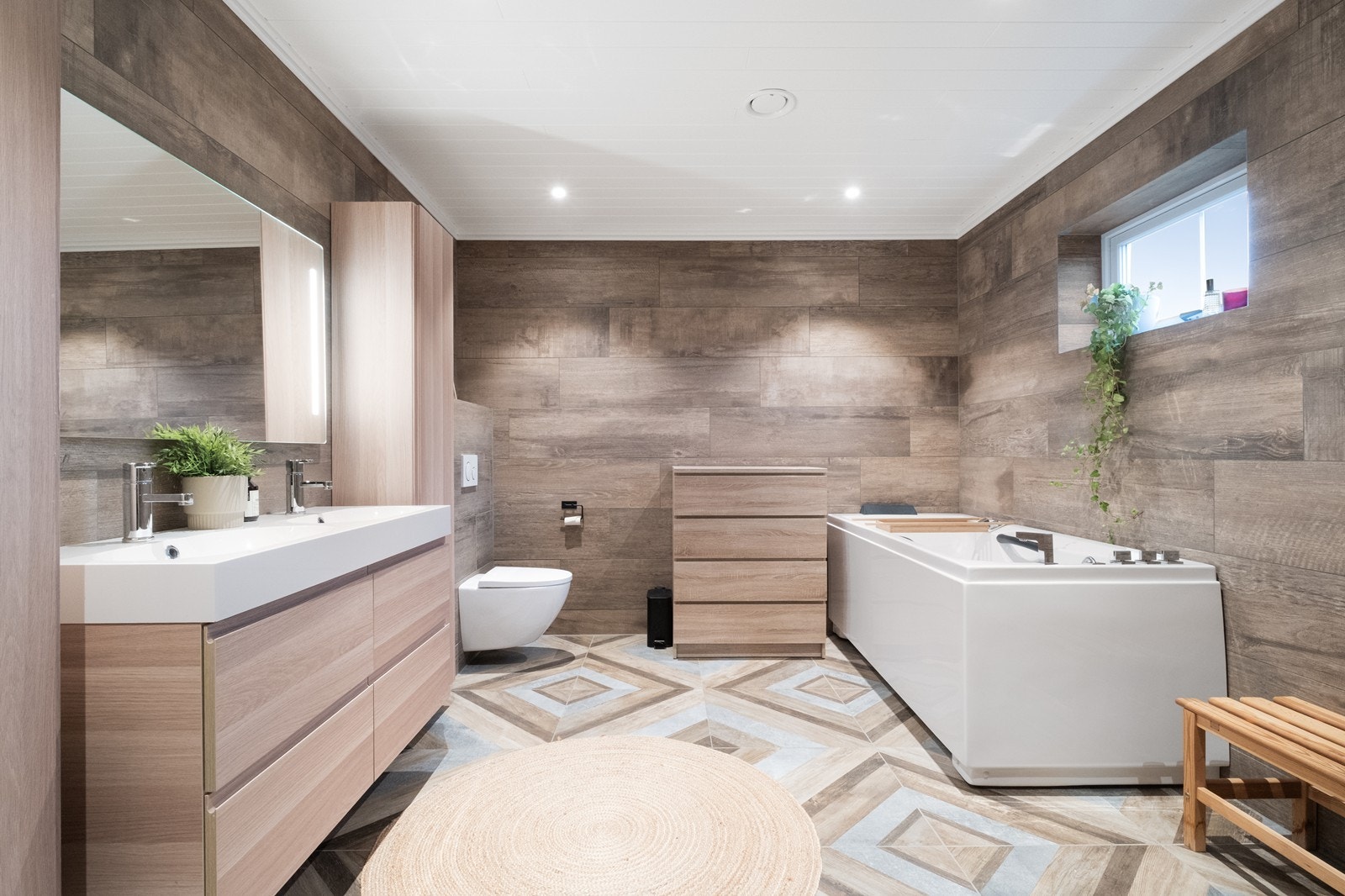 Badet i 1. etg. er utstyrt med badekar, vegghengt wc, heldekkende servant, belyst speil og innholdsrik baderomsinnredning med både under- og høyskap. Galleribilde