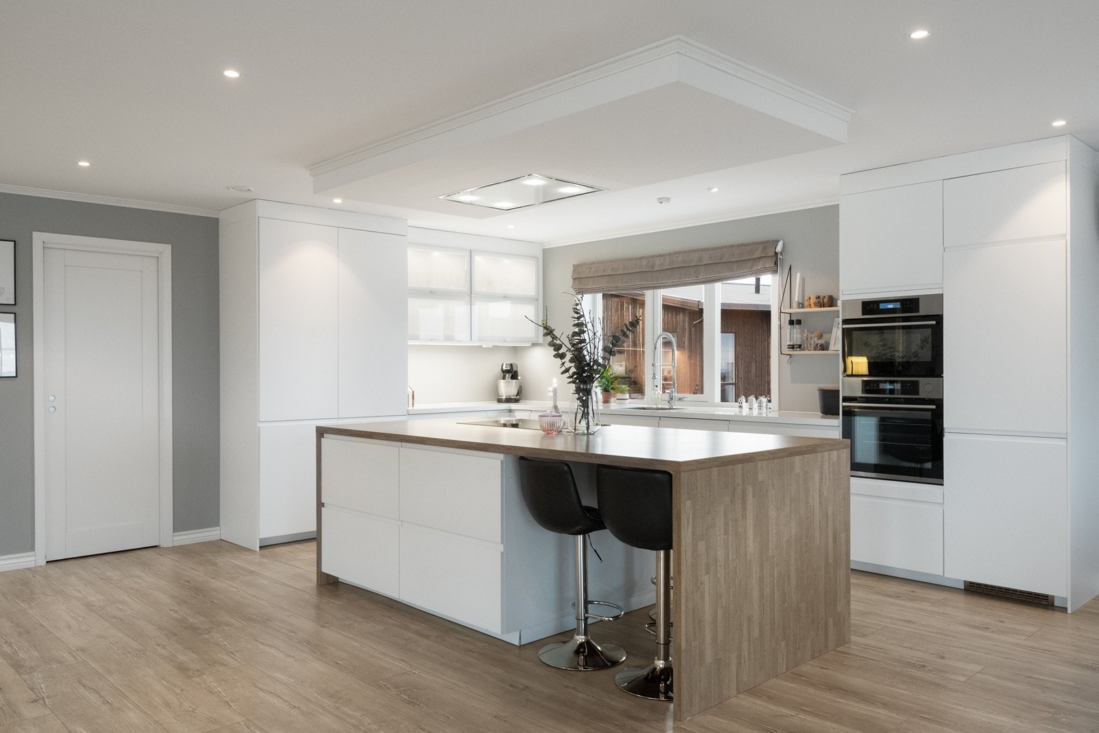 Kjøkkenøy med platetopp og takhengt ventilator gir en funksjonell arbeidsplass kombinert med spiseplass. Galleribilde