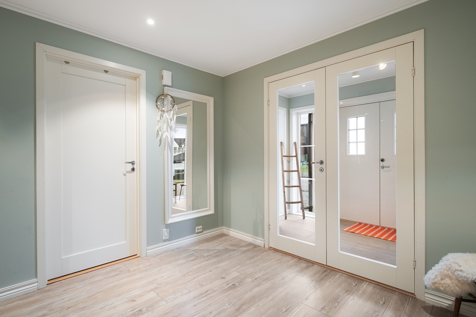 Hallen er åpen og lys, med glassdører mot entrè. Galleribilde