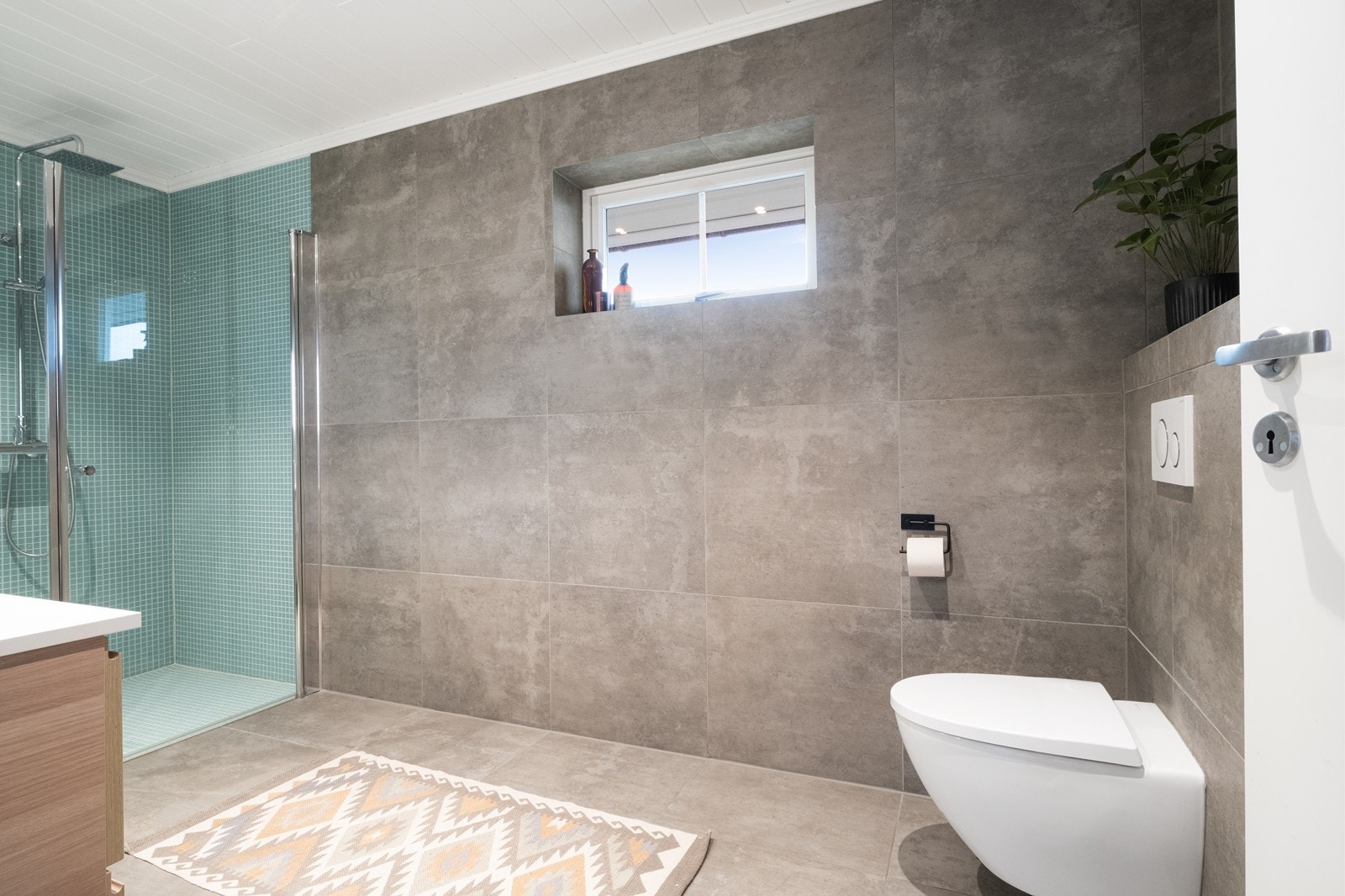 Vegghengt toalett og speil med lys gir en moderne og funksjonell innredning. Galleribilde