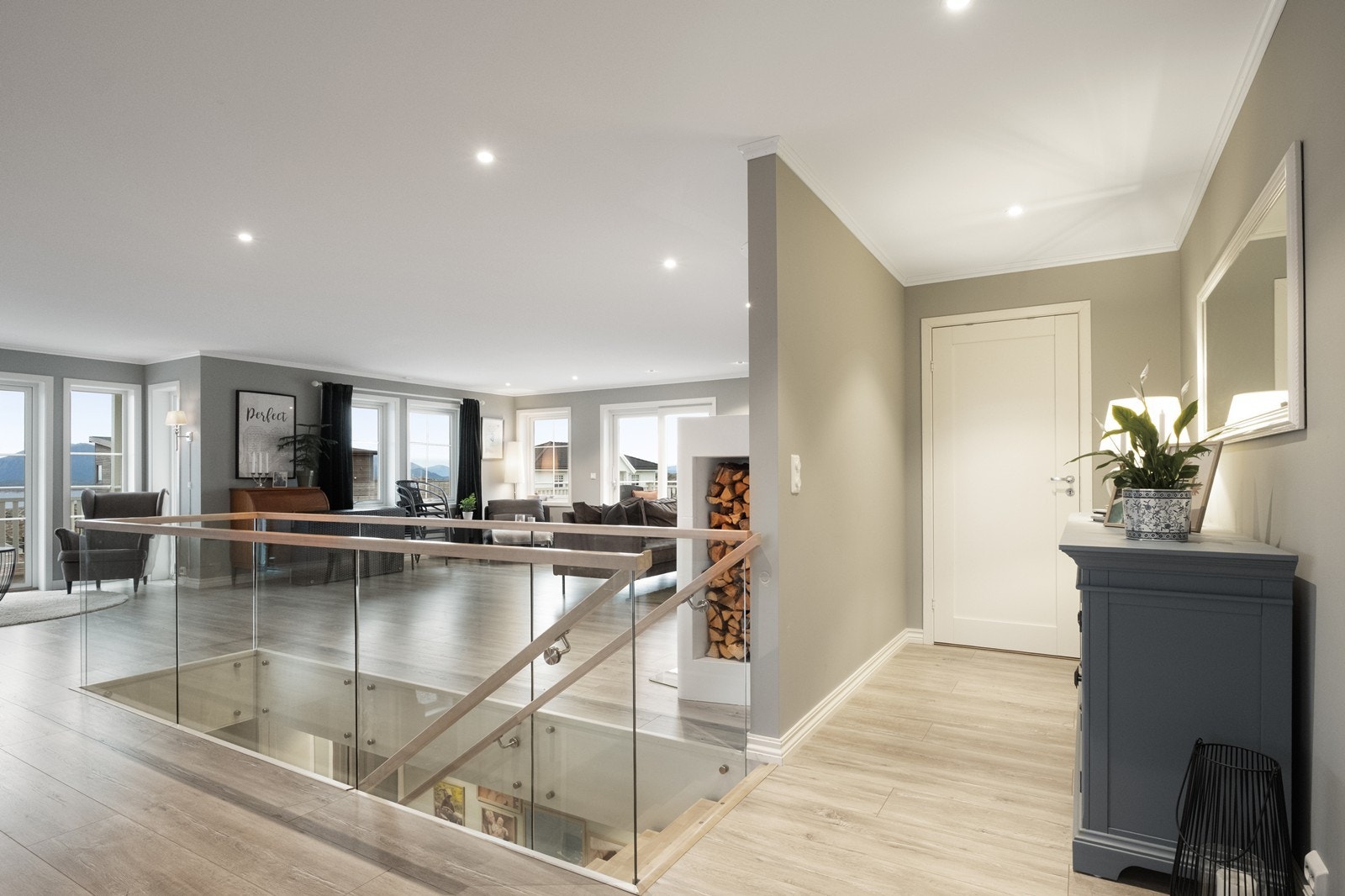 En moderne trapp med glassrekkverk tar deg rett fra entrèen og opp i stue- og kjøkkenområdet. Galleribilde