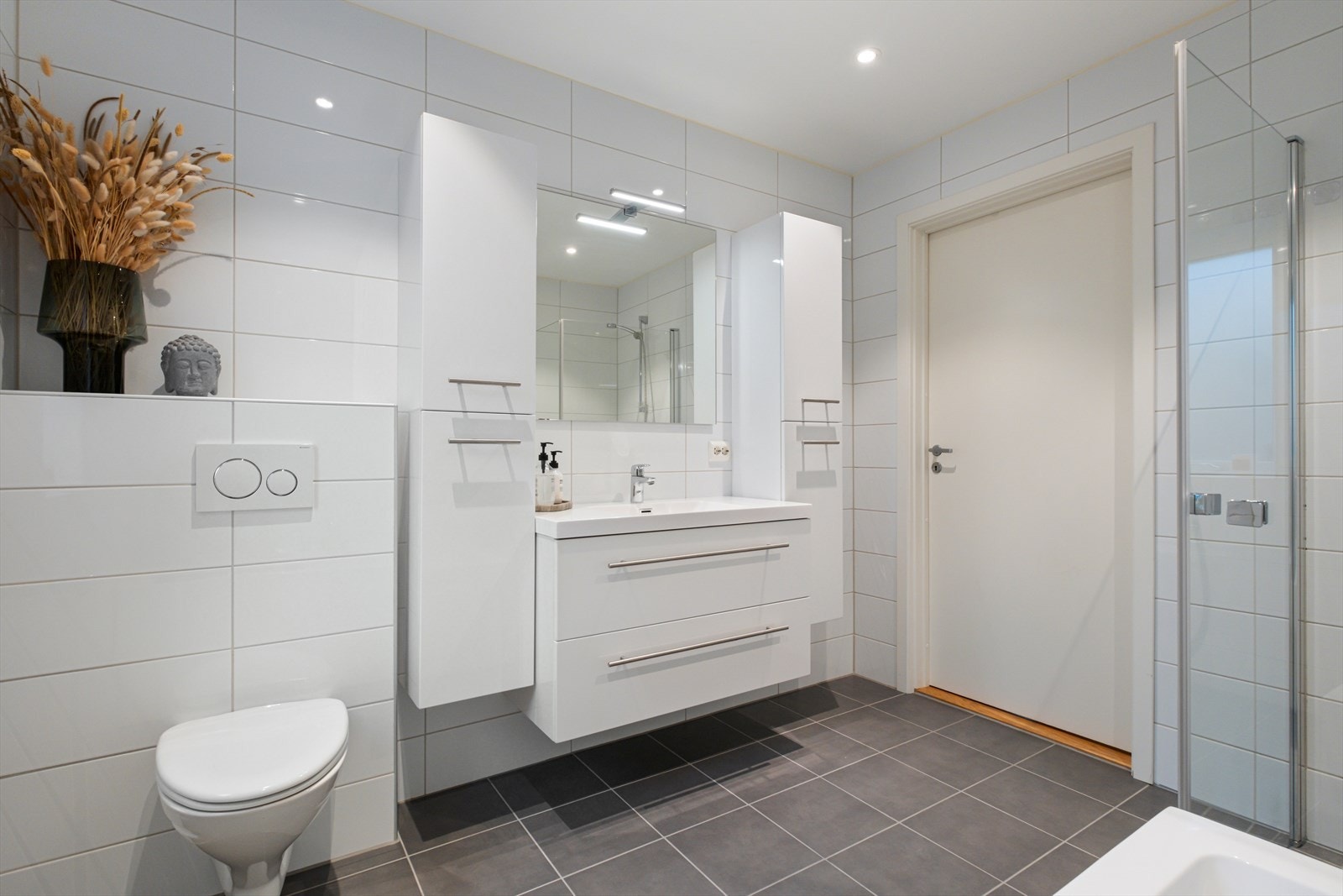 Veggmontert toalett og innredning med nedfelt servant gir praktisk bruk av rommet. Galleribilde