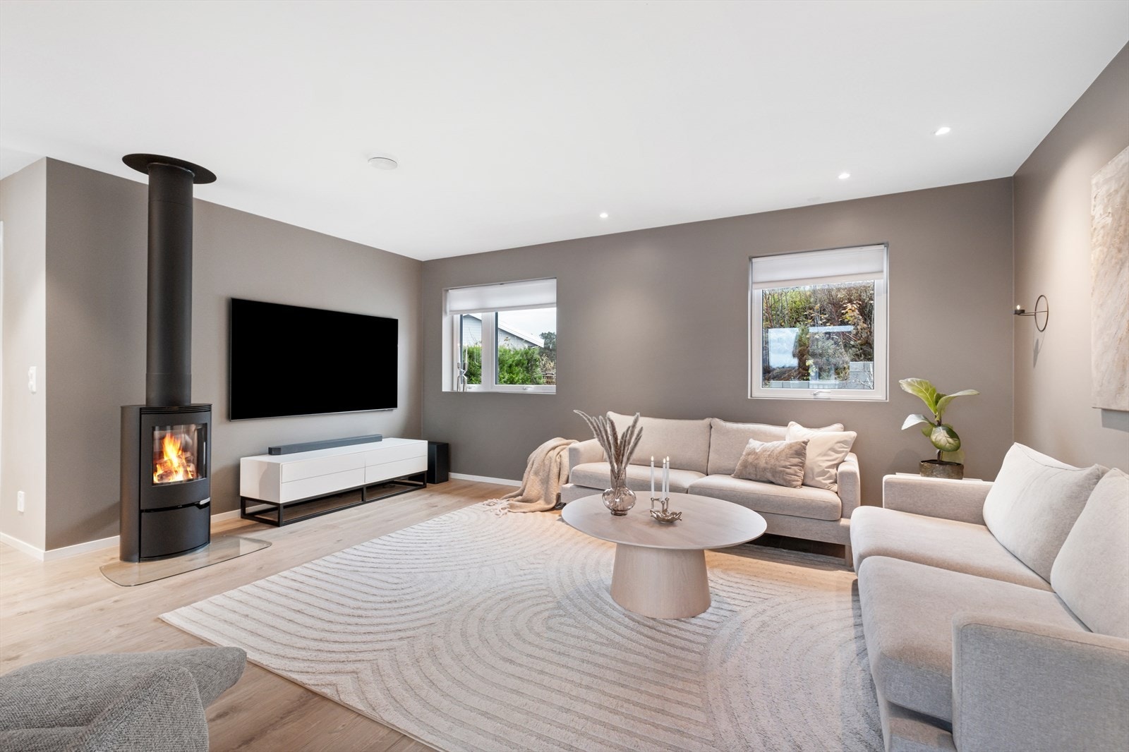 Vedovn bidrar med jevn varme i stuen og her er downlights i taket Galleribilde