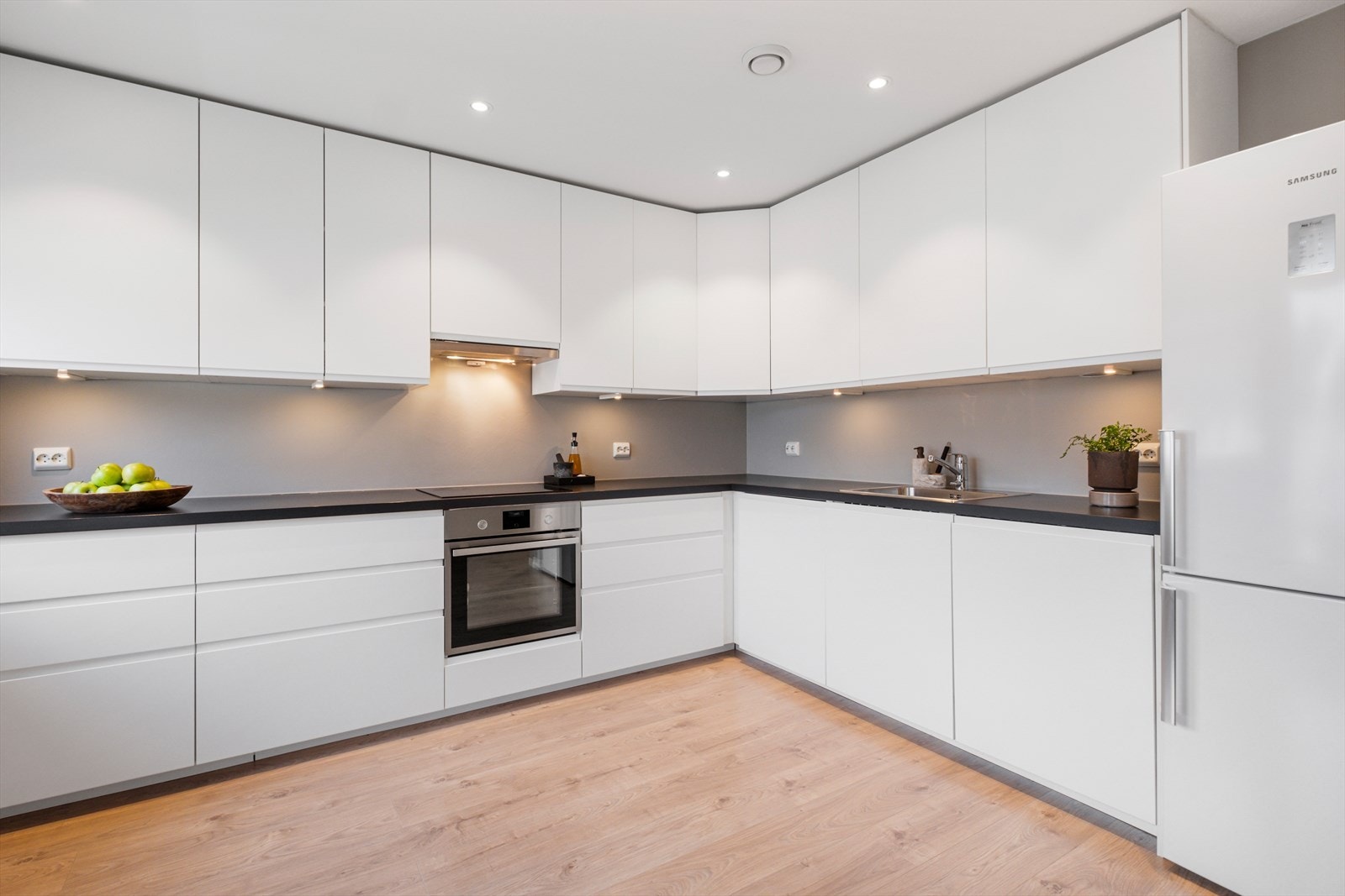 Kjøkkenet har overskap og underskap med slette fronter, benkeplate av laminat, oppvaskmaskin, platetopp, stekeovn, frittstående kjøleskap, komfyrvakt og vannstoppsystem. Det er kjøkkenventilator med avtrekk ut. Galleribilde