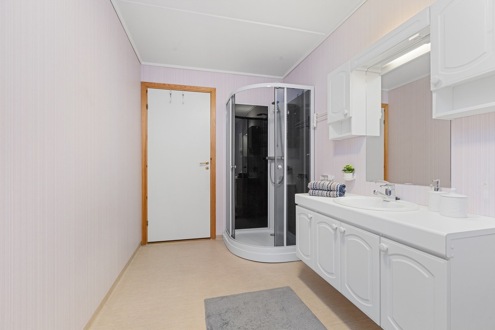 Bad/wc med belegg på gulv med varmekabler og tapetserte vegger. Nytt dusjkabinett og nytt wc fra 2022 Galleribilde