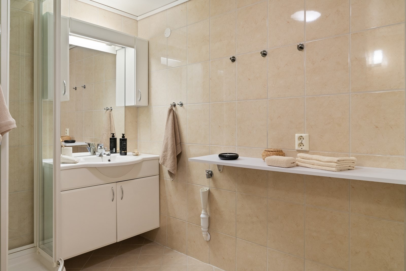 Her får du dusjkabinett, romslig baderomsinnredning med godt med oppbevaringsplass samt praktiske hyller for håndklær og nødvendigheter. Galleribilde