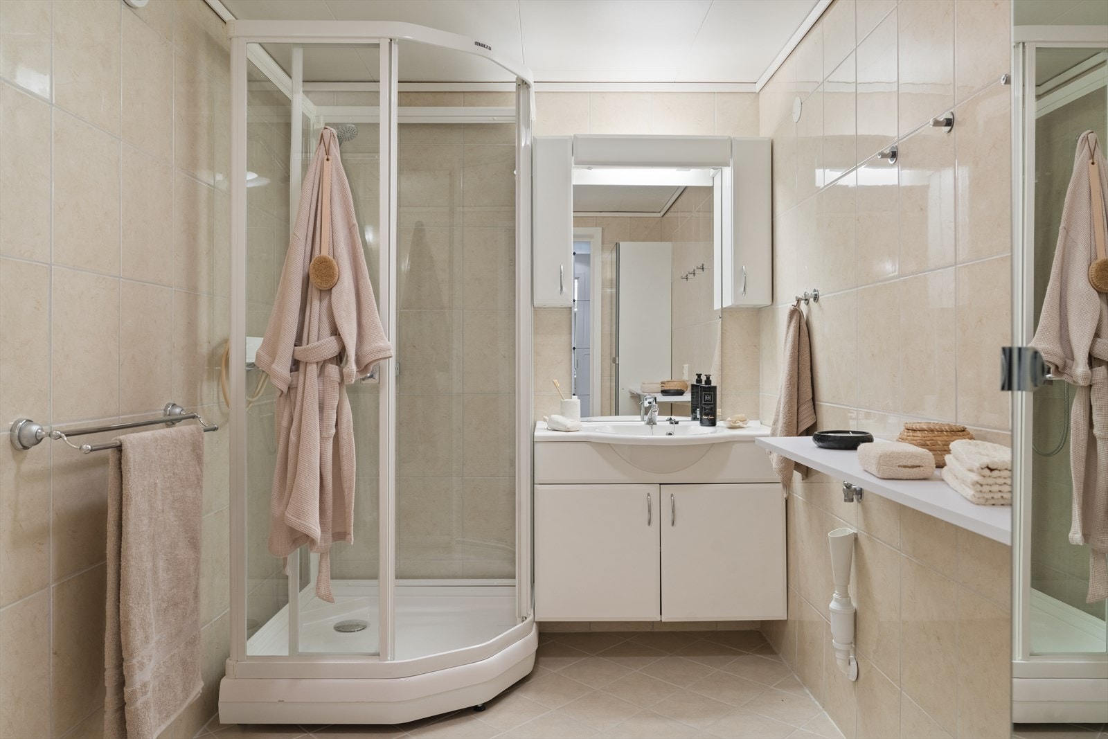 Her får du dusjkabinett, romslig baderomsinnredning med godt med oppbevaringsplass samt praktiske hyller for håndklær og nødvendigheter. Galleribilde