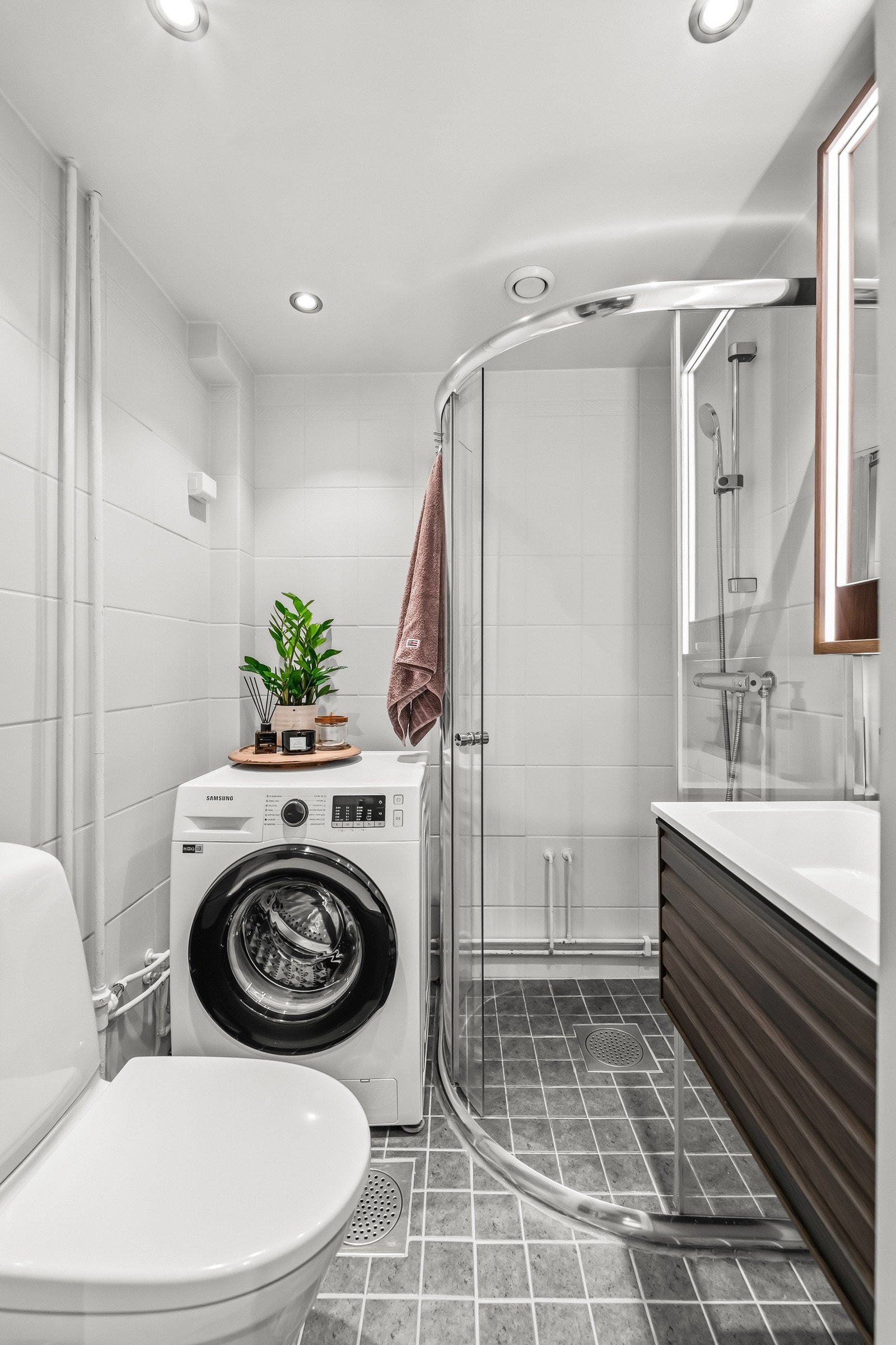 Praktisk bad med opplegg for vaskemaskin, dusjhjørne og servant med underskuffer Galleribilde