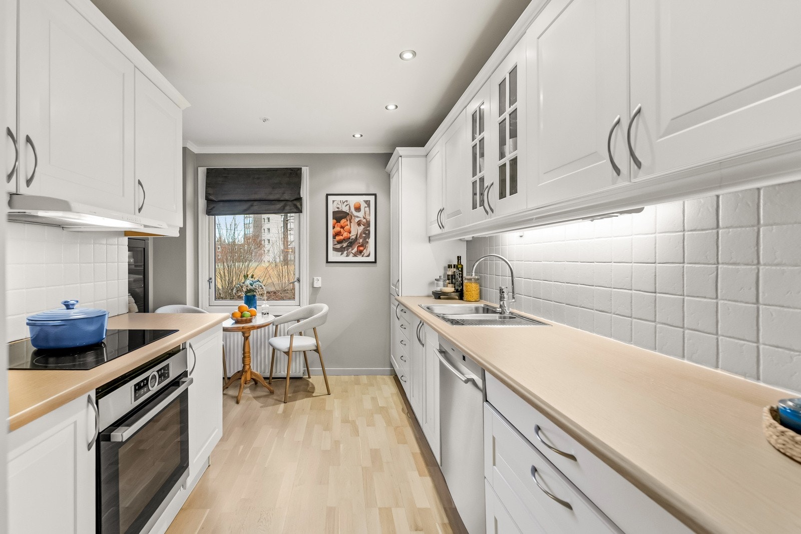 Tidløst kjøkkenet med hvite fronter og kjeramiske fliser over benkeplate Galleribilde