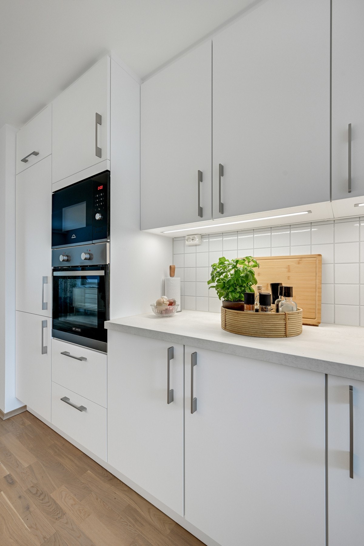 Det er fliser mellom benkeplaten og overskapene. Galleribilde