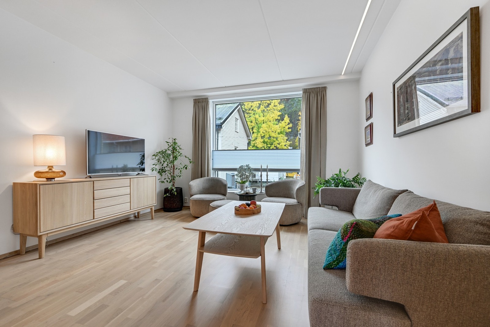 Stuen byr på god plass for sofagruppe, salongbord og tv-bord. Galleribilde