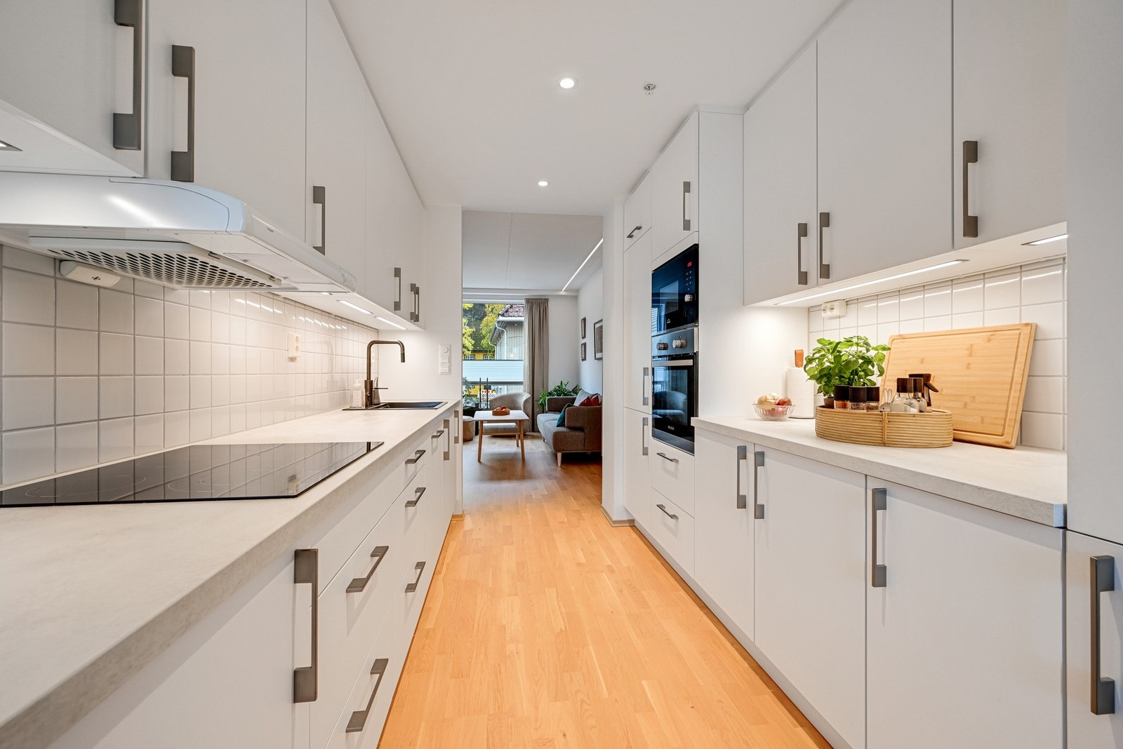 Lyst og pent kjøkken med slette fronter og benkeplate i laminat. Galleribilde