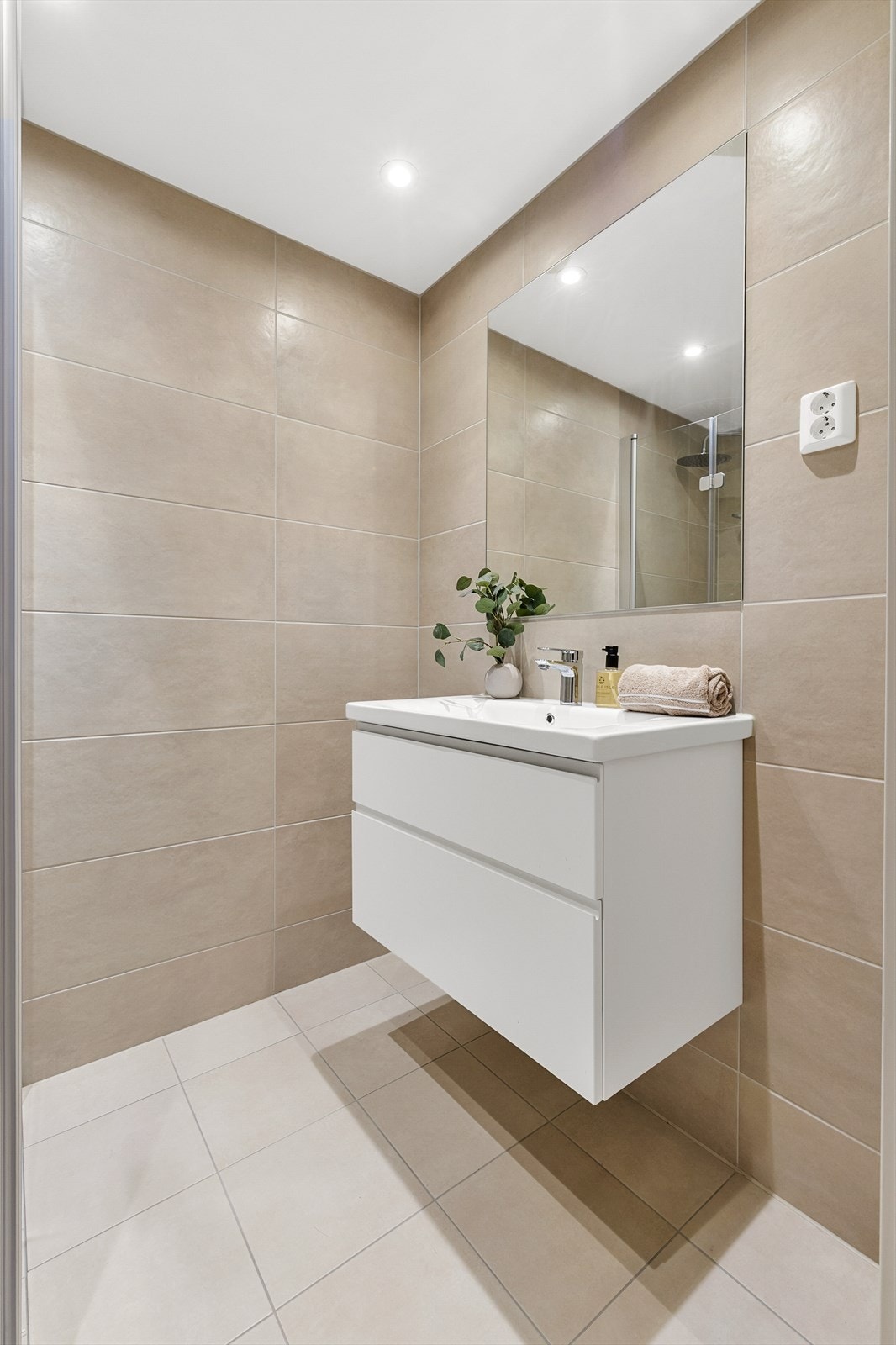 Stilren og delikat baderomsinnredning med veggmontert speil. Dimbare spotter i taket. Galleribilde