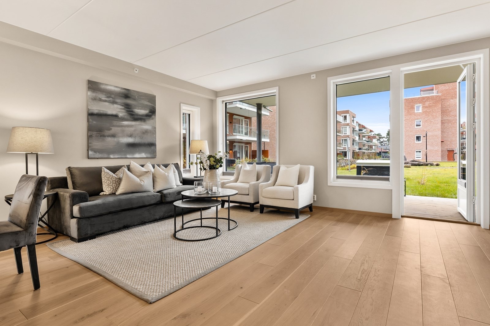 Åpen og elegant stue med store vindusflater mot uteplassen Galleribilde