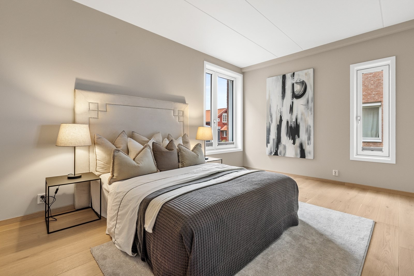 Lyst og luftig hovedsoverom med store vinduer, god plass til dobbeltseng og nattbord - et avslappende rom for hvile og komfort. Galleribilde