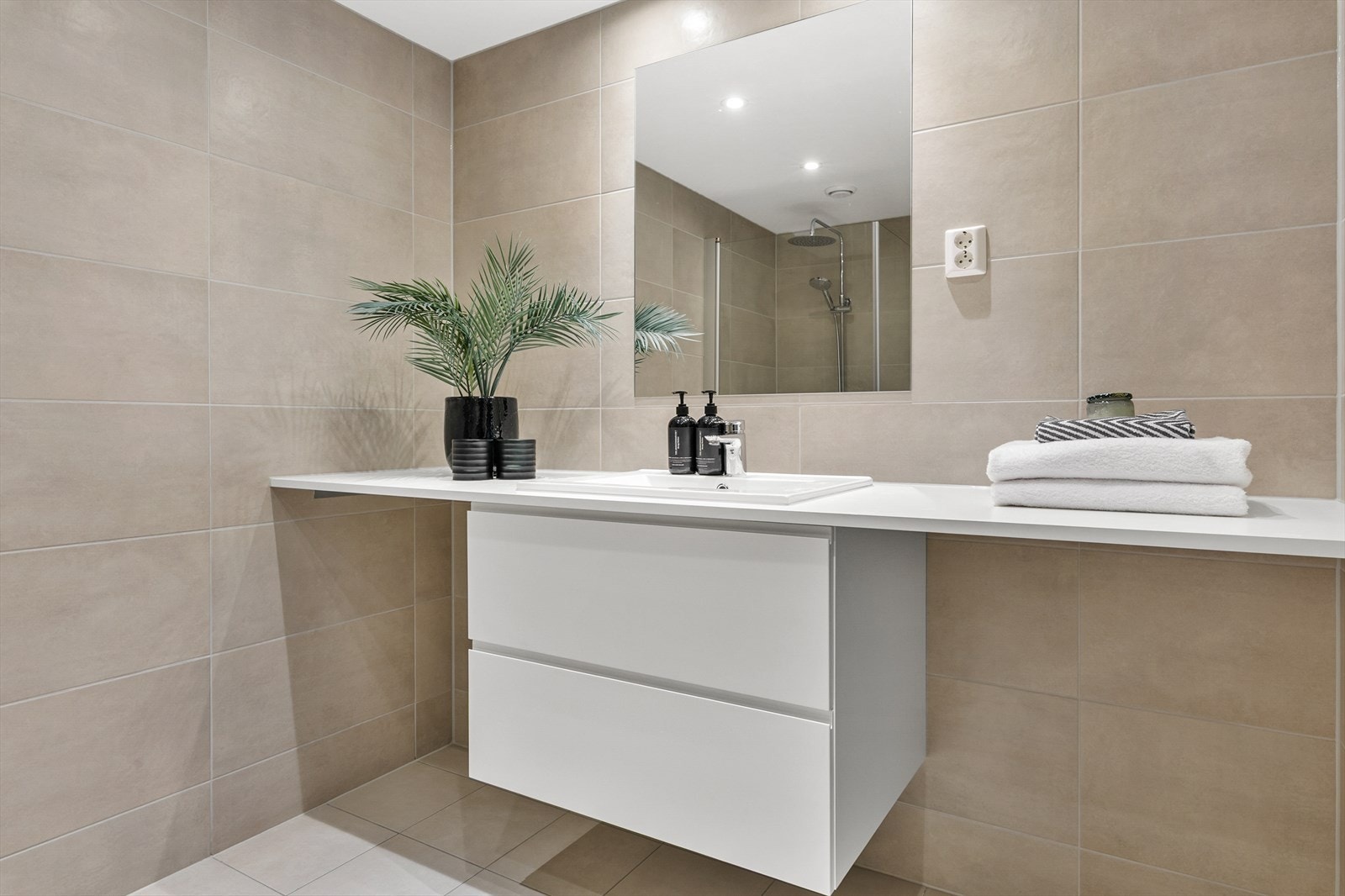 Smart servantløsning med heldekkende benkeplate over vaskemaskin og tørketrommel. Galleribilde