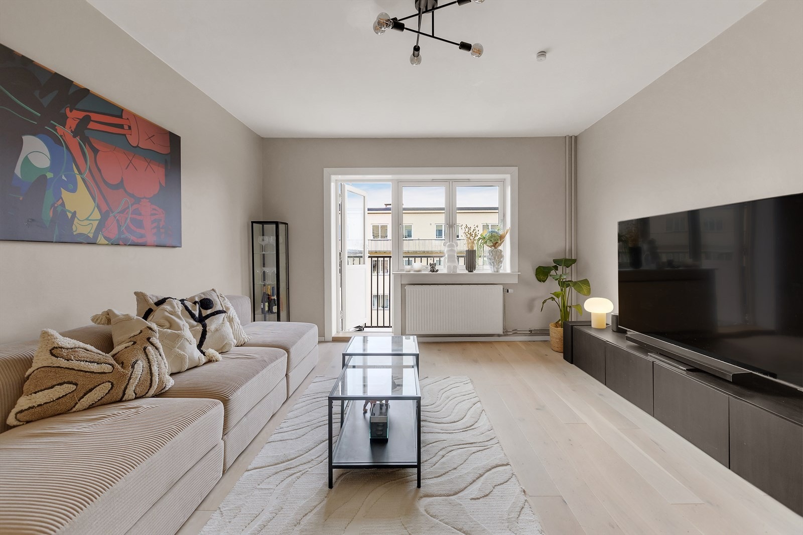 Lys, innbydende og romslig stue med store vindusflater og utgang til balkong. Galleribilde