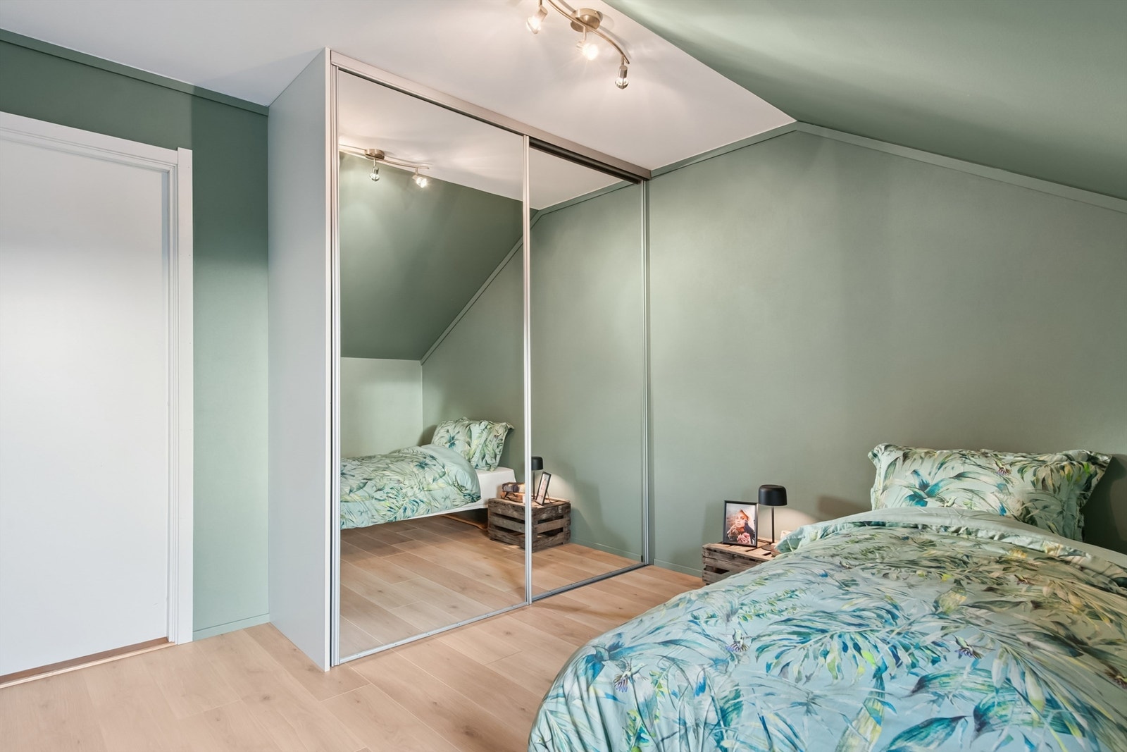 En romslig skyvedørsgarderobe med speilfronter gir rikelig med oppbevaringsplass. Galleribilde