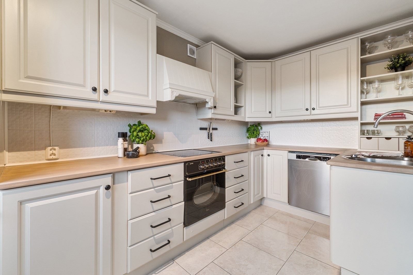 Innredningen har profilerte fronter og heltre benkeplate, med malte veggplater over benken som gir et rent og tidløst uttrykk Galleribilde