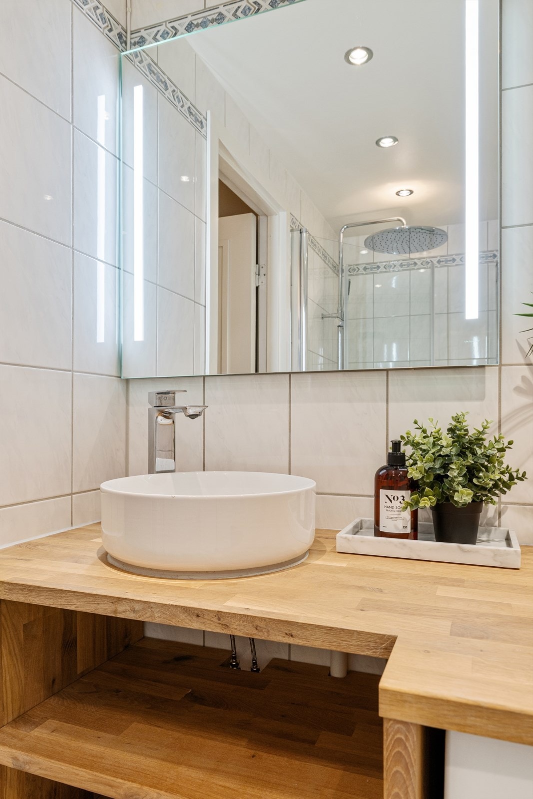 Baderomsinnredning med servant, blandebatteri og lysspeil Galleribilde