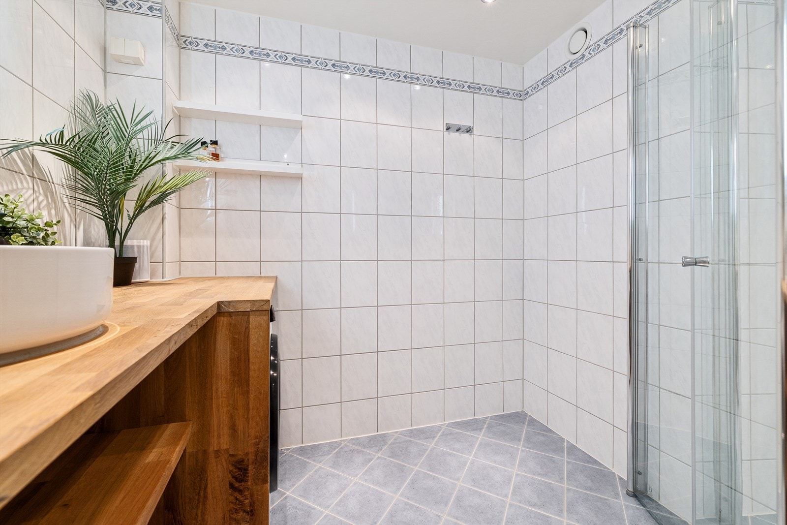 Helfliset bad med varmekabler i gulv, downlights i himling og opplegg for vaskemaskin Galleribilde