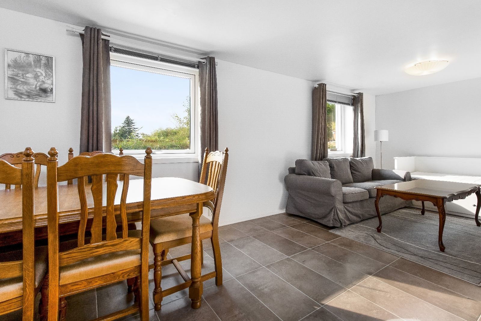 Romslig stue innredet med både spisegruppe og sofa. Galleribilde