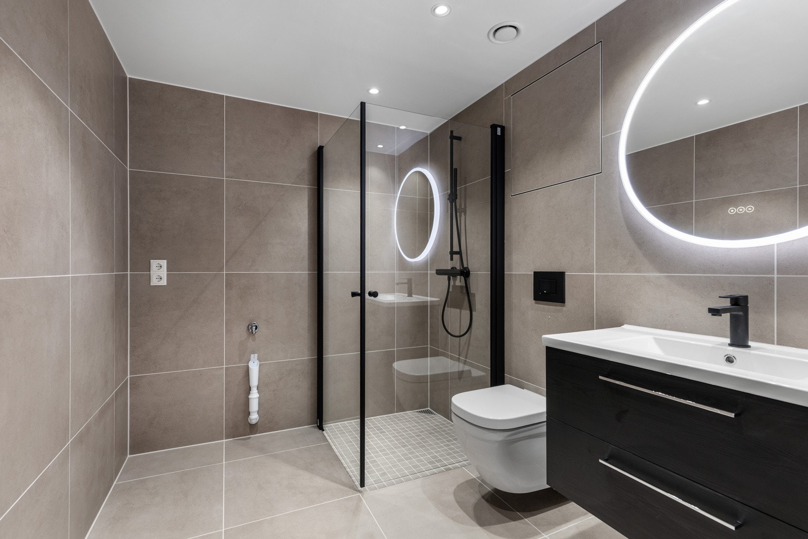 Leiligheten får et lekkert bad med moderne farger og innredning. Galleribilde