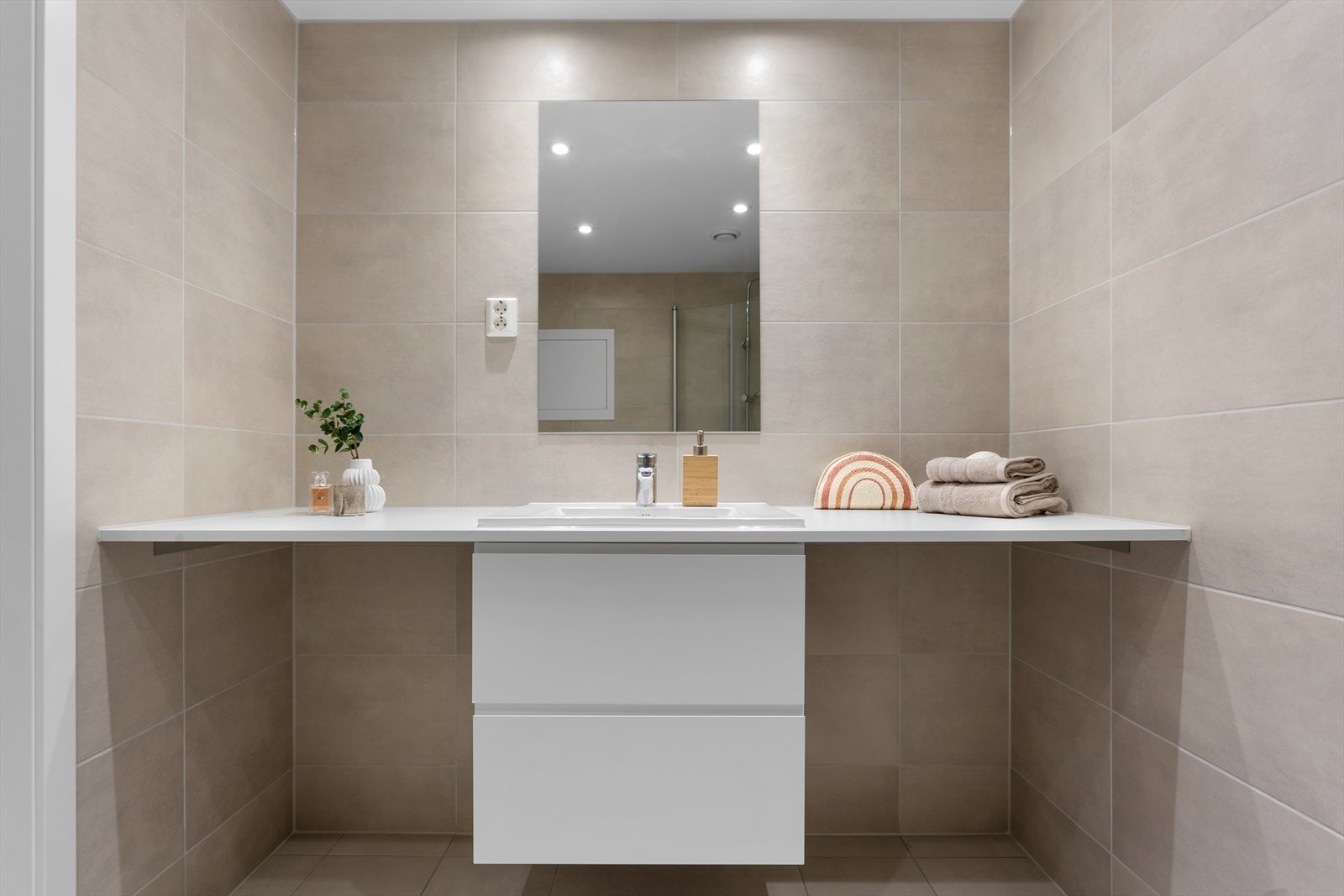 Bad med plass til vask og tørk under servantbenken. Galleribilde