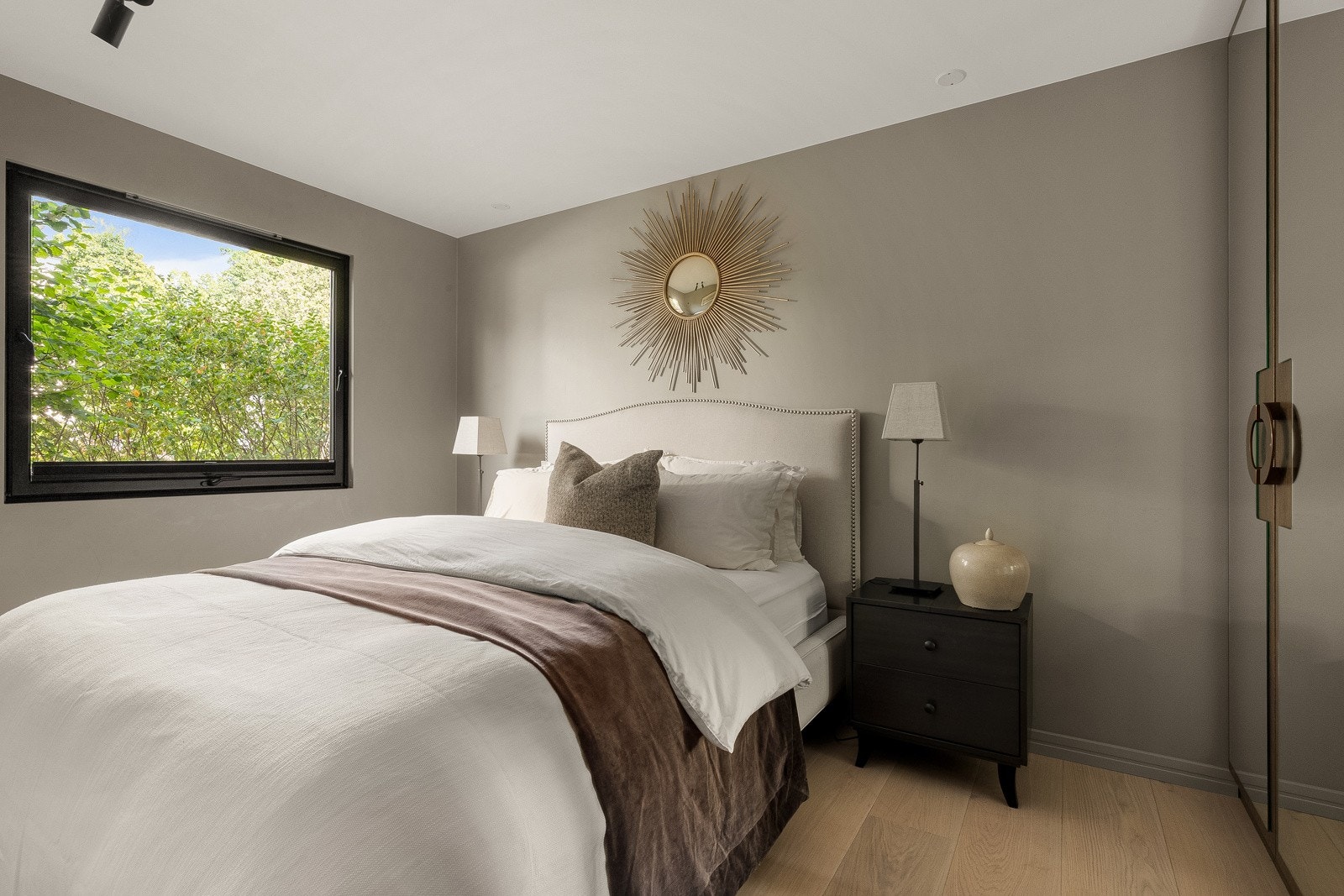 Leiligheten har to soverom, begge gjennomført i en elegant grå og sort palett. I masterdelen finner man en seks meter lang, snekkerbygd garderobe.