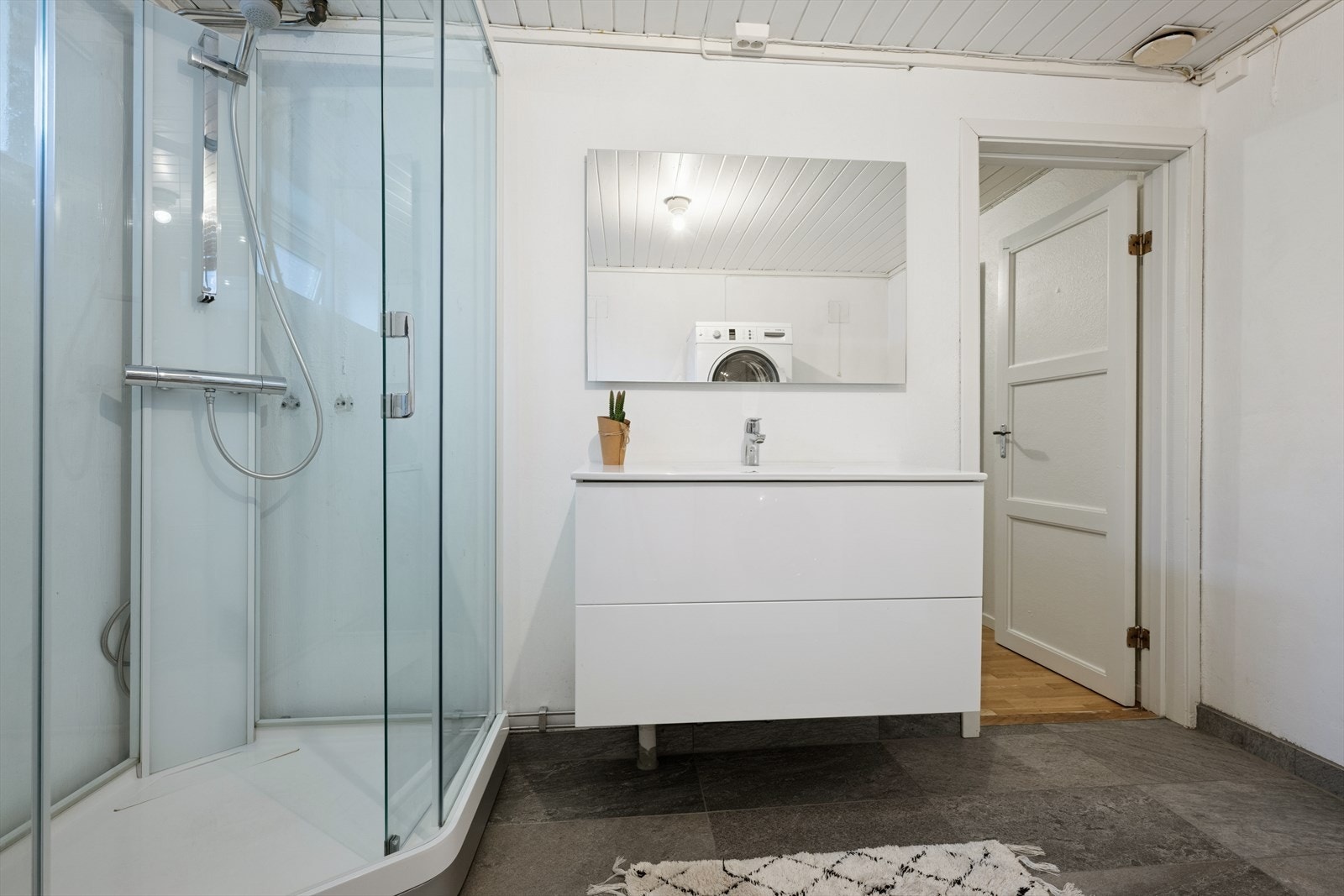 Vaskerommet er innredet med toalett, dusjkabinett, lys baderomsinnredning og opplegg for vaskemaskin/tørketrommel. Galleribilde