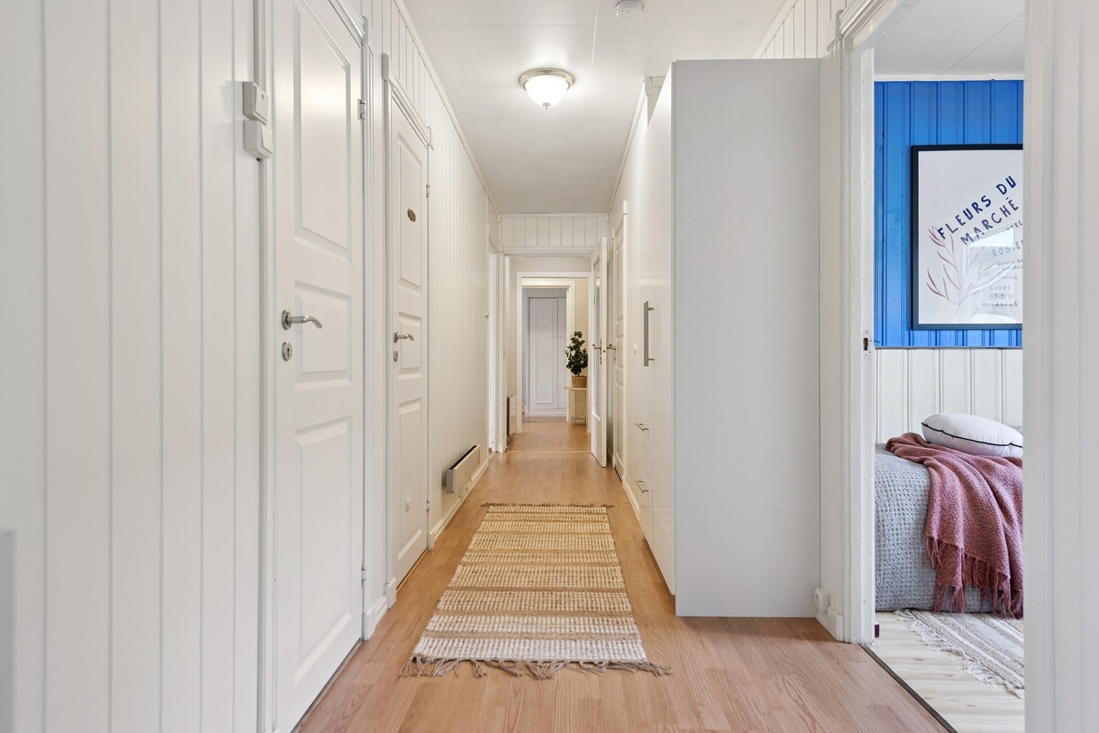 En gang leder videre til boligens fire soverom og bad. Galleribilde