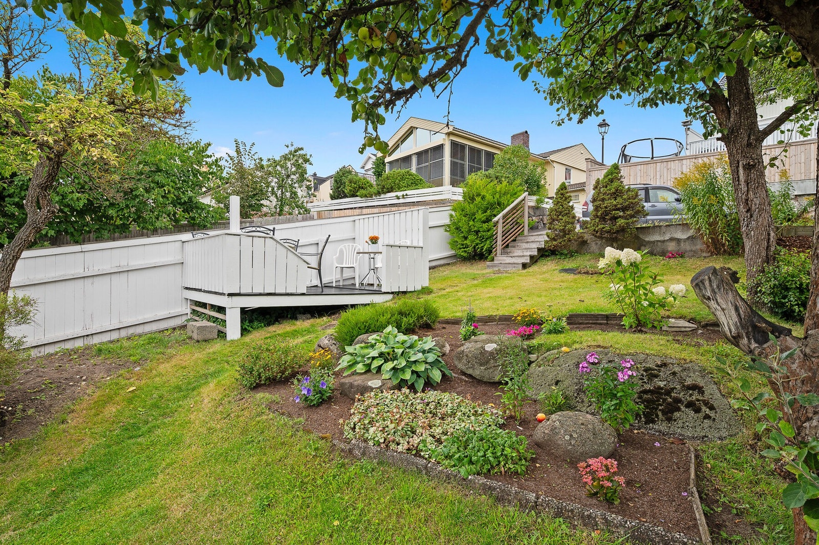 Idylliske fellesarealer med frukttrær, hyggelig beplantning og sitteplasser. Galleribilde